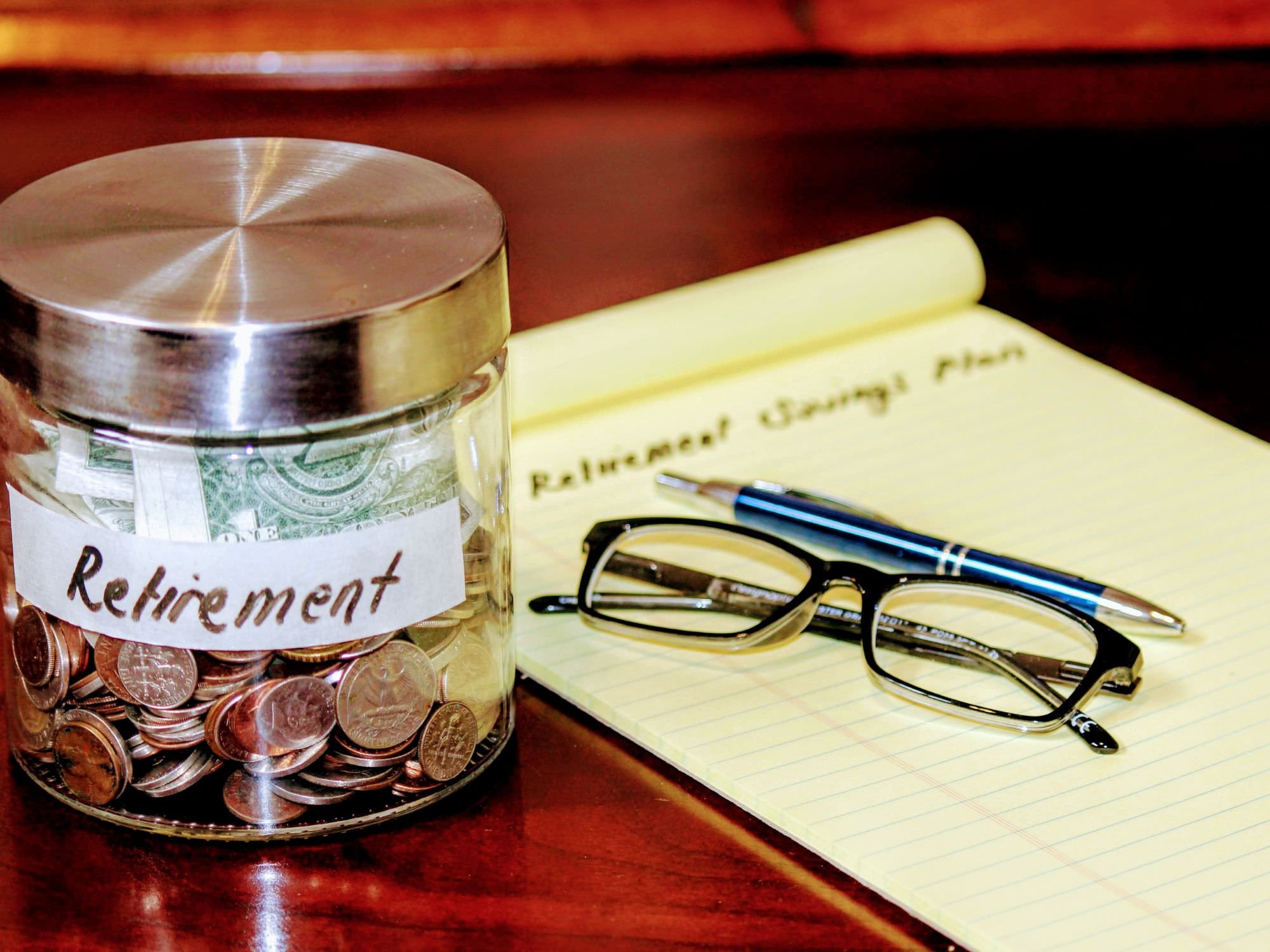 jar with the words 'retirement' on it with notepad
