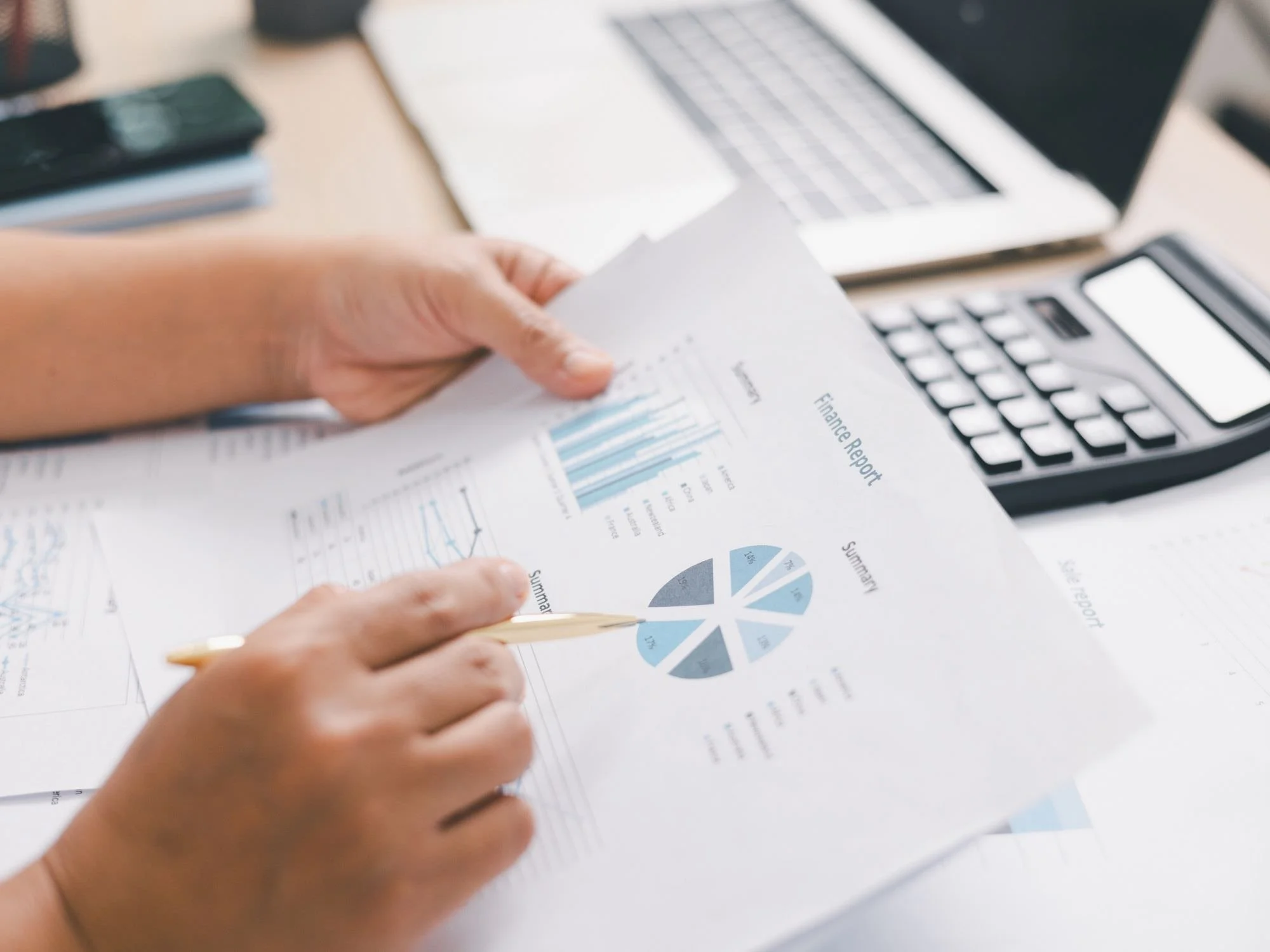 Someone pointing to a summary graph on a piece of paper  - Do I Need a Financial Advisor?