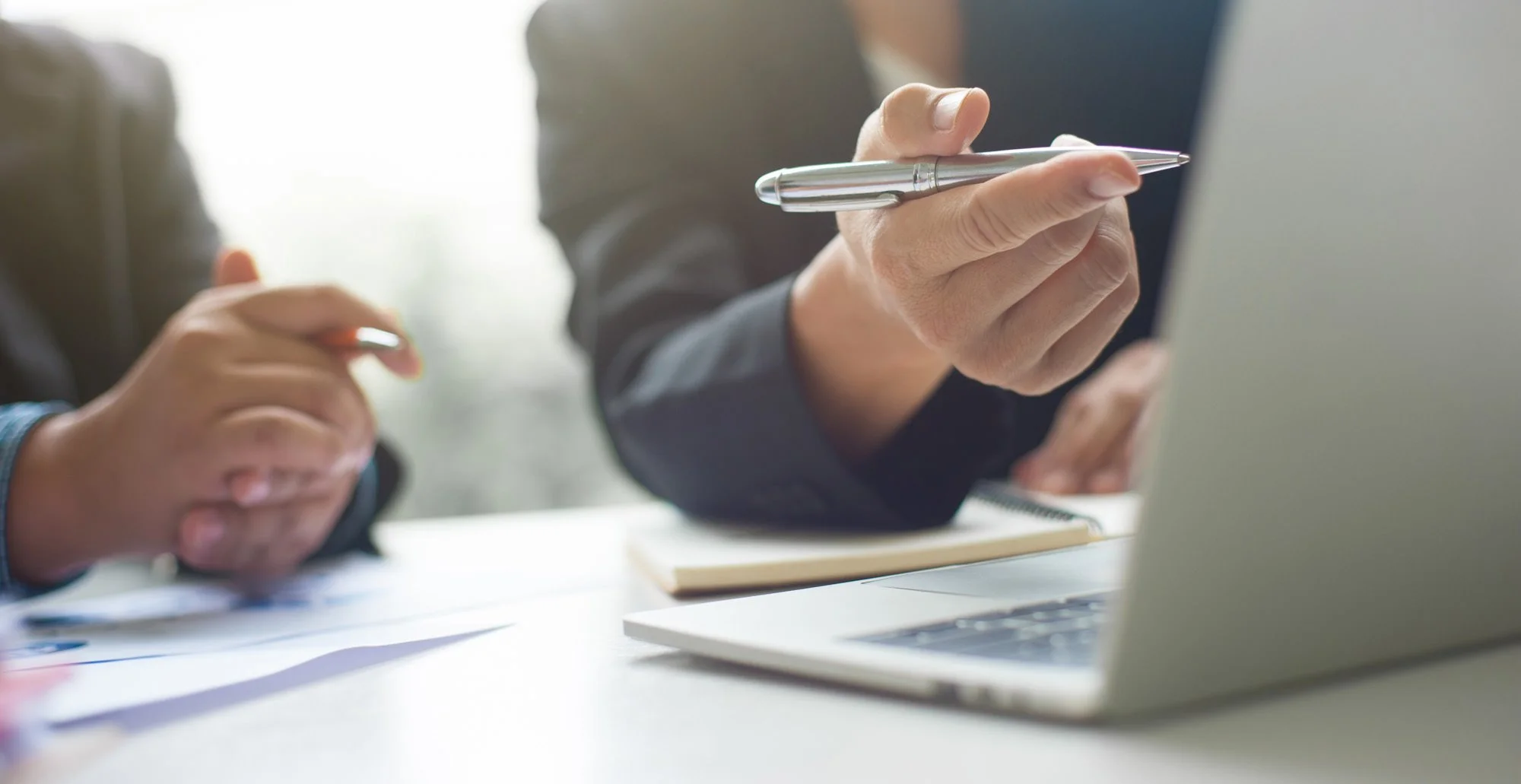 Two people looking at financial documents on a laptop - Fiduciary Standard Advisor