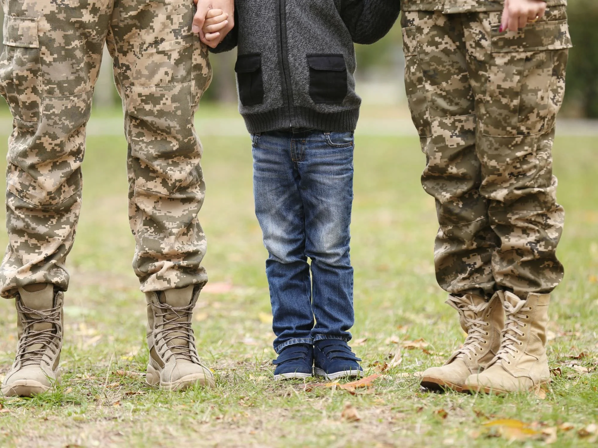 Mom and dad in fatigues with son in the middle.