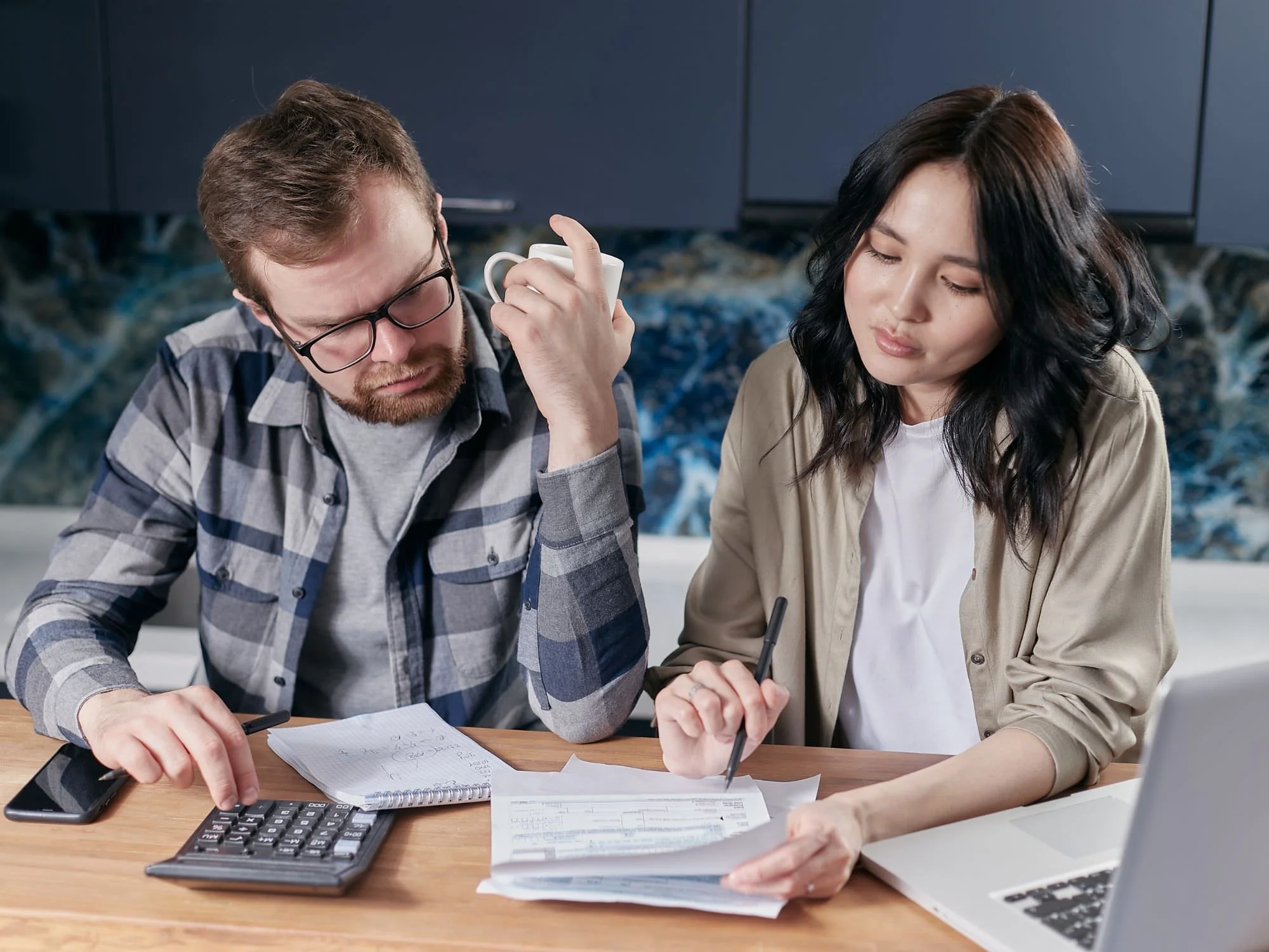 man and woman looking at bills with a calculator - 401k divorce