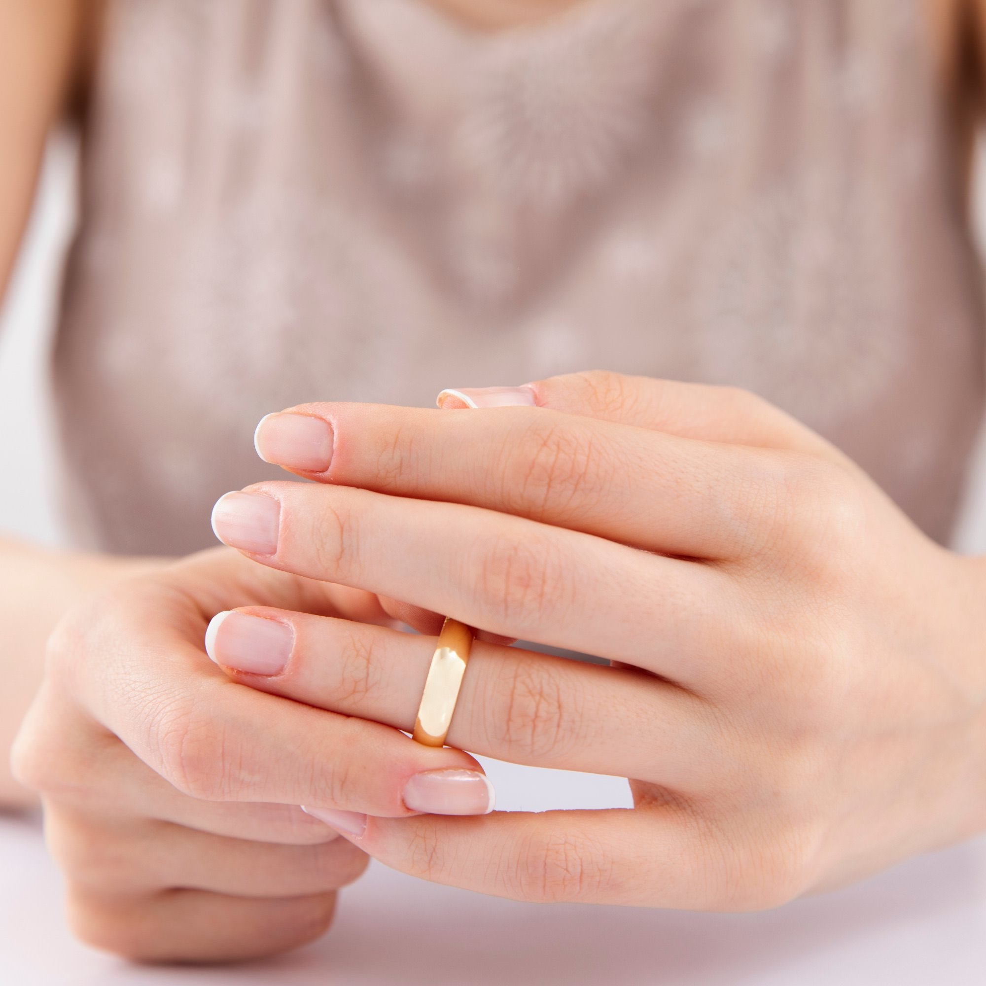 women twisting gold wedding band - financial survival after divorce