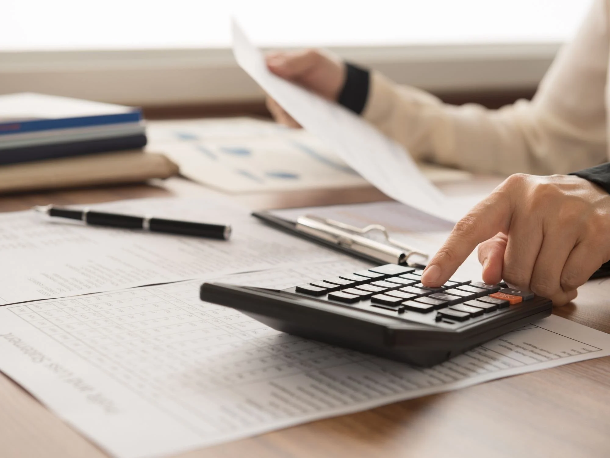 Paperwork in the calculator on a desk. - Do I Need a Financial Advisor?