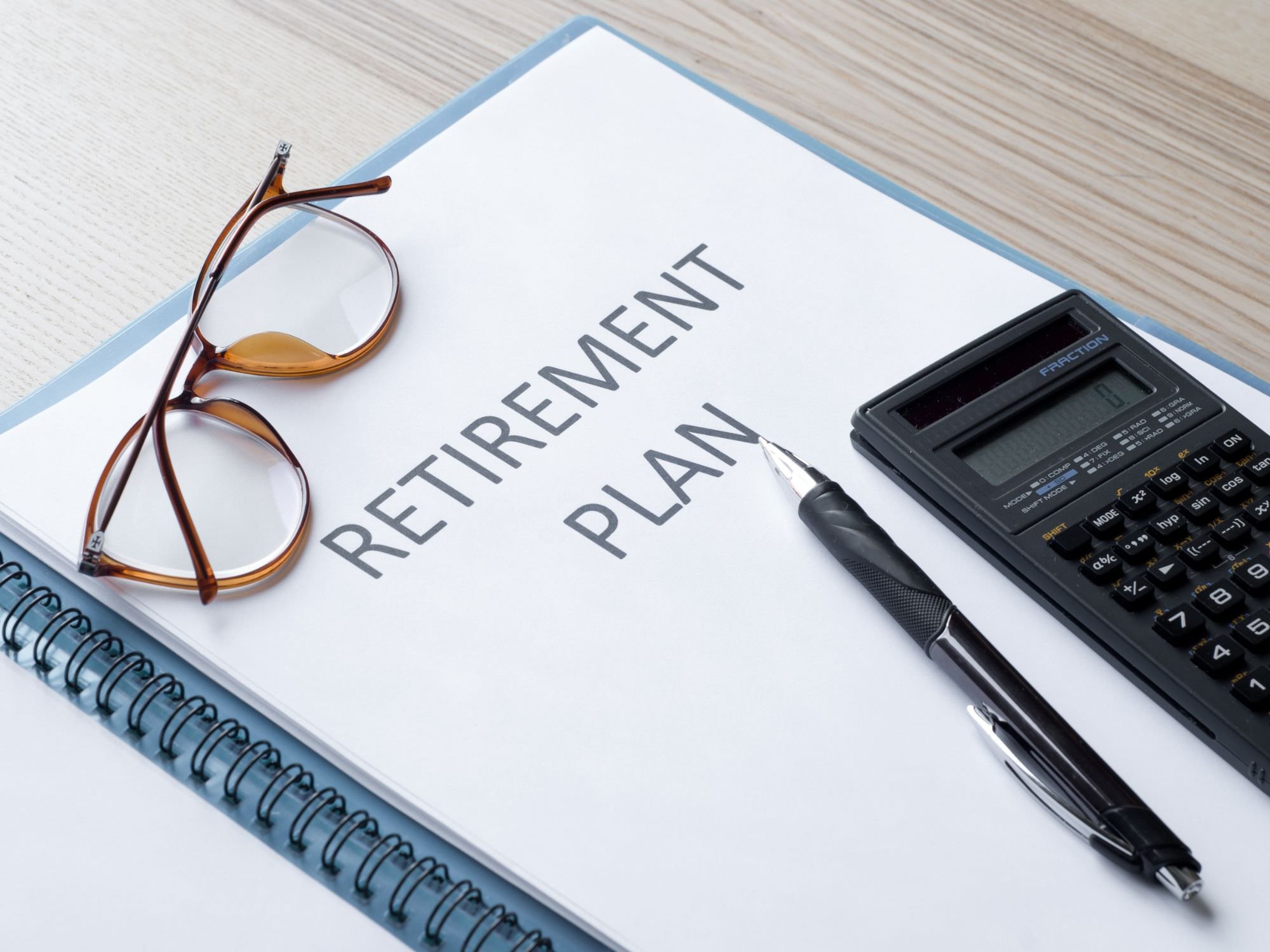 Retirement plan binder, calculator, and pen and glasses  - ira divorce