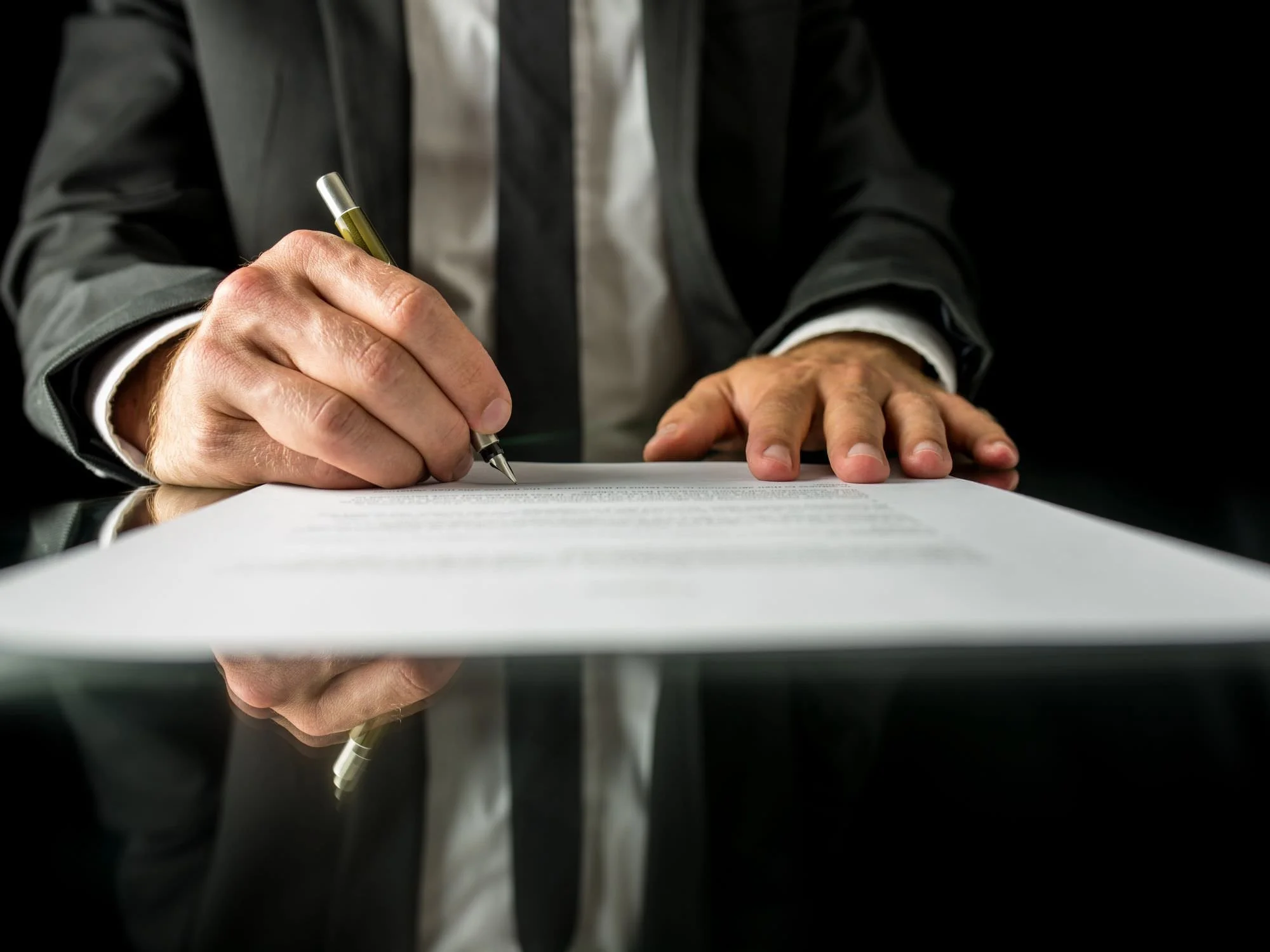 man signing a document