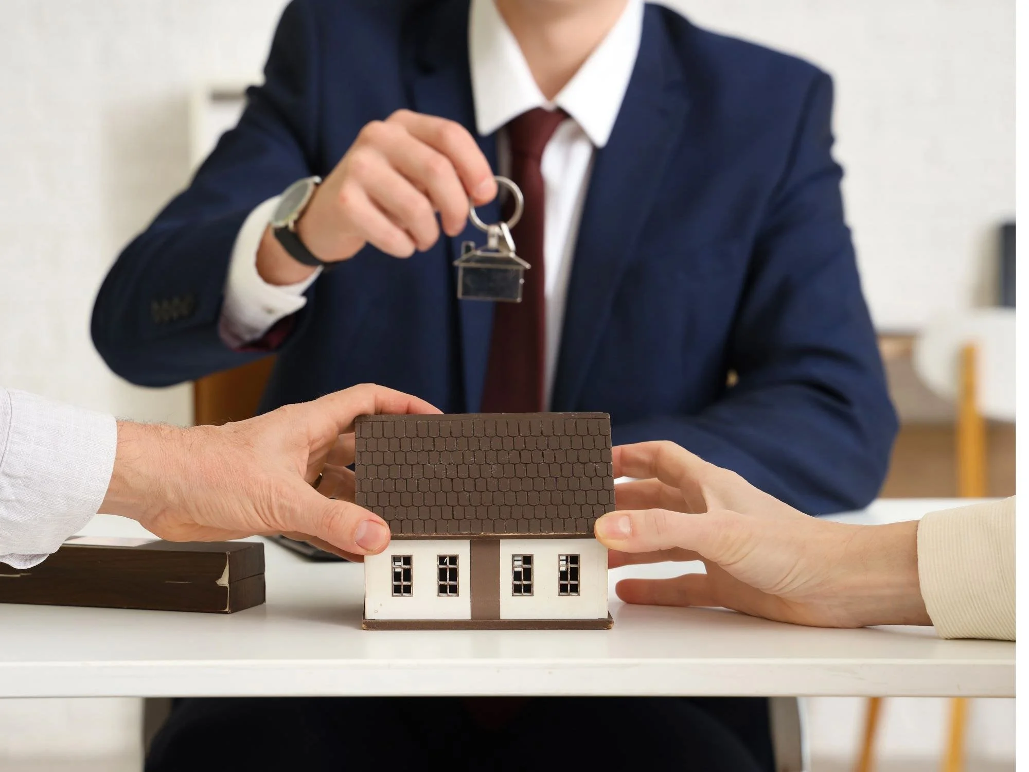 two people tugging at a toy house - Dividing Assets in Divorce