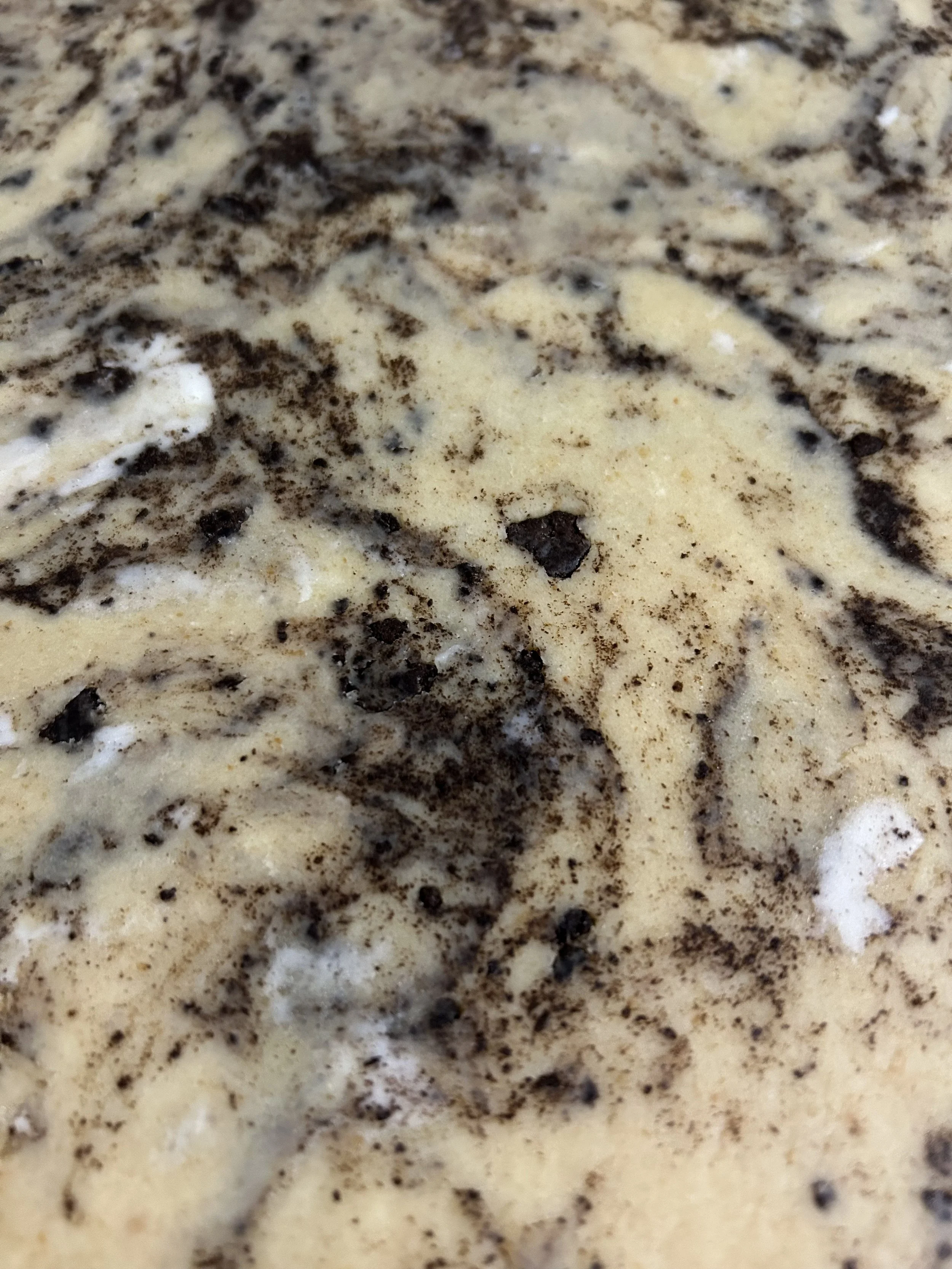 Close-up of a mixture of vanilla ice cream with chocolate cookie crumbs.