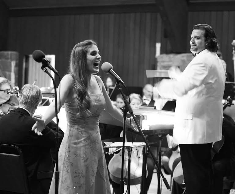 A black and white image of April Amante singing 