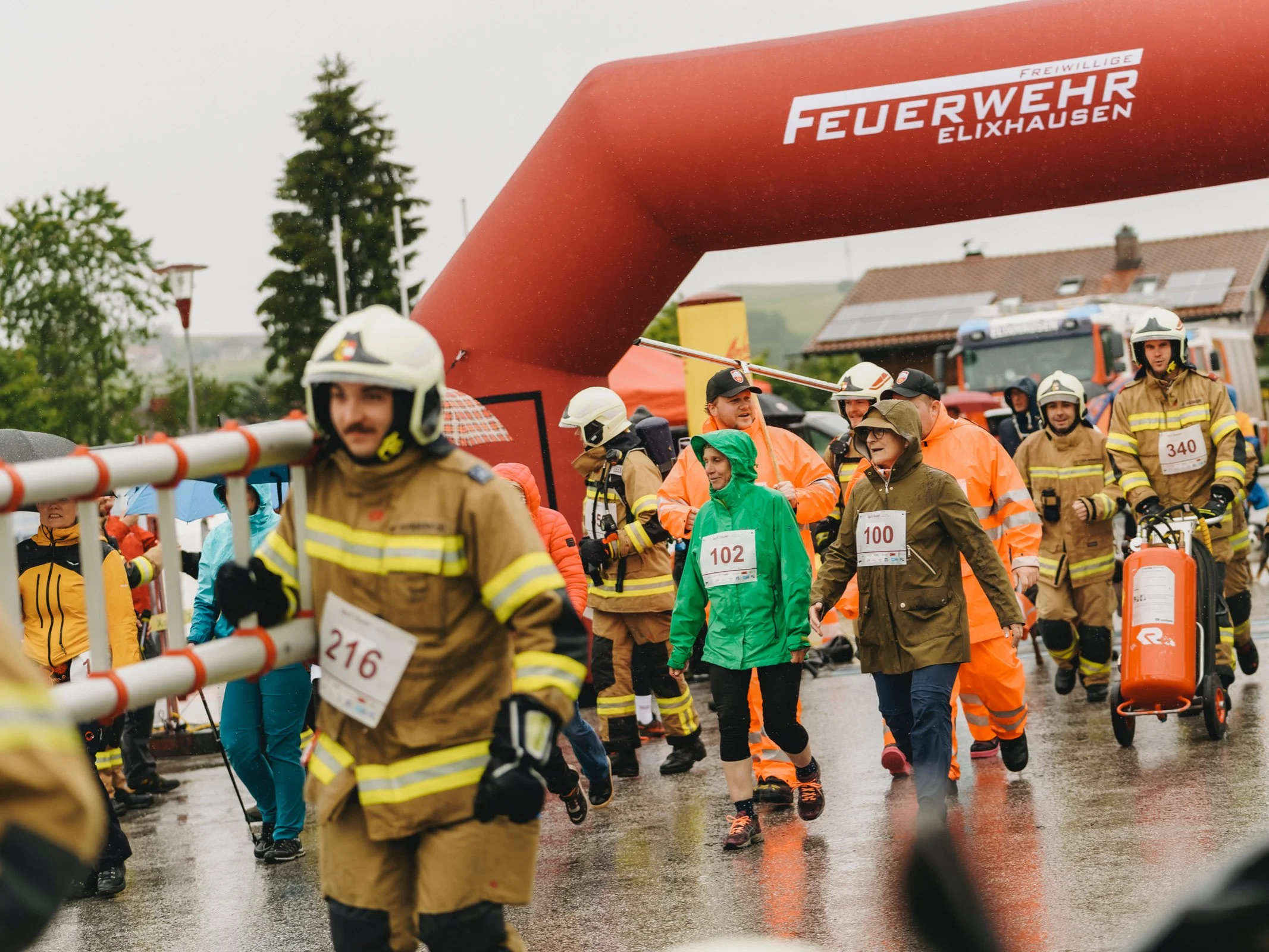 Feuerwehrleute im Vordergrund und Teilnehmende aus der Bevölkerung nach dem Start beim Charitylauf lauf:feuer 2024 in Elixhausen