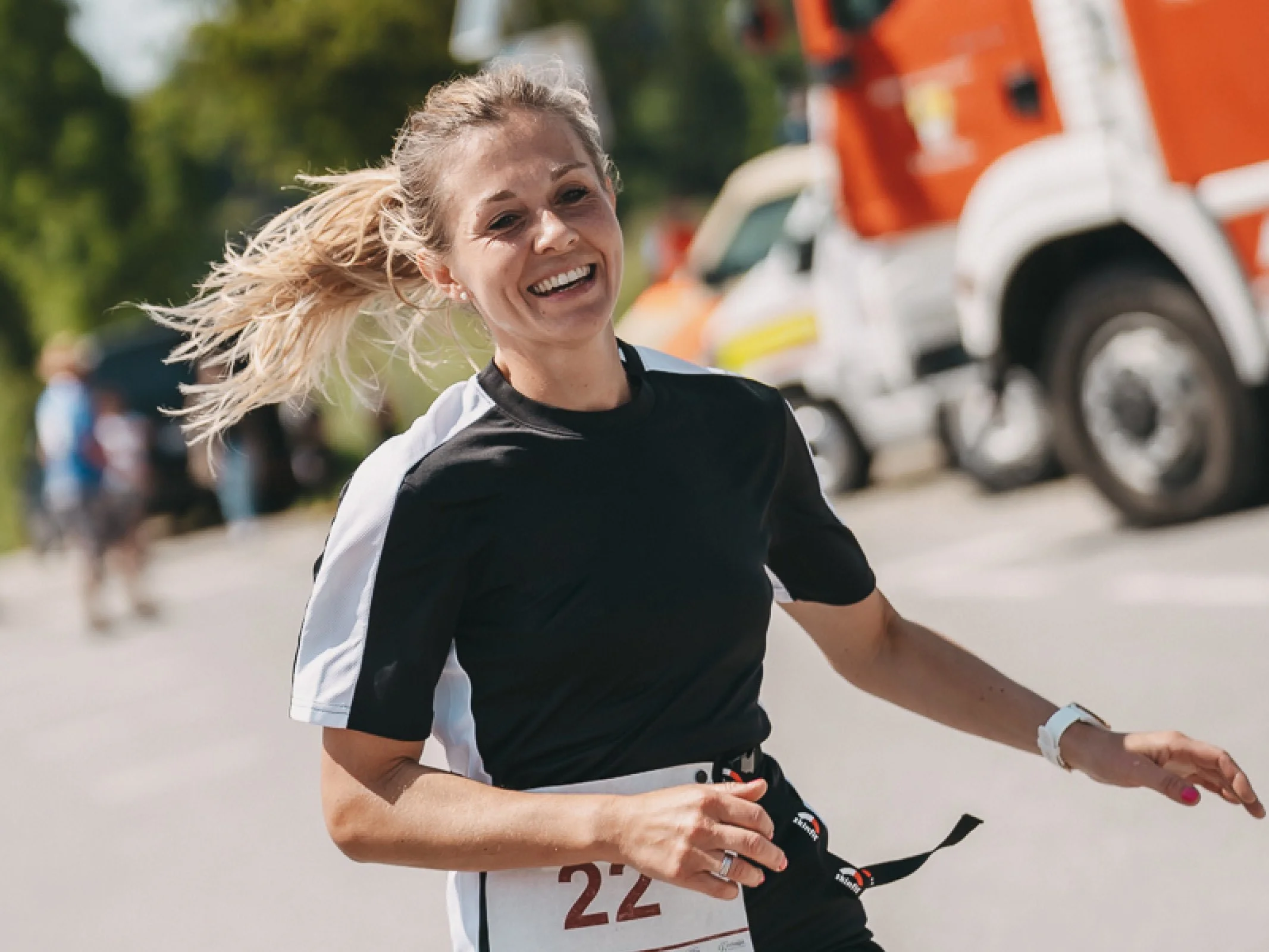 Strahlende Läuferin beim Zieleinlauf des Charitylaufs lauf:feuer 2023 in Elixhausen