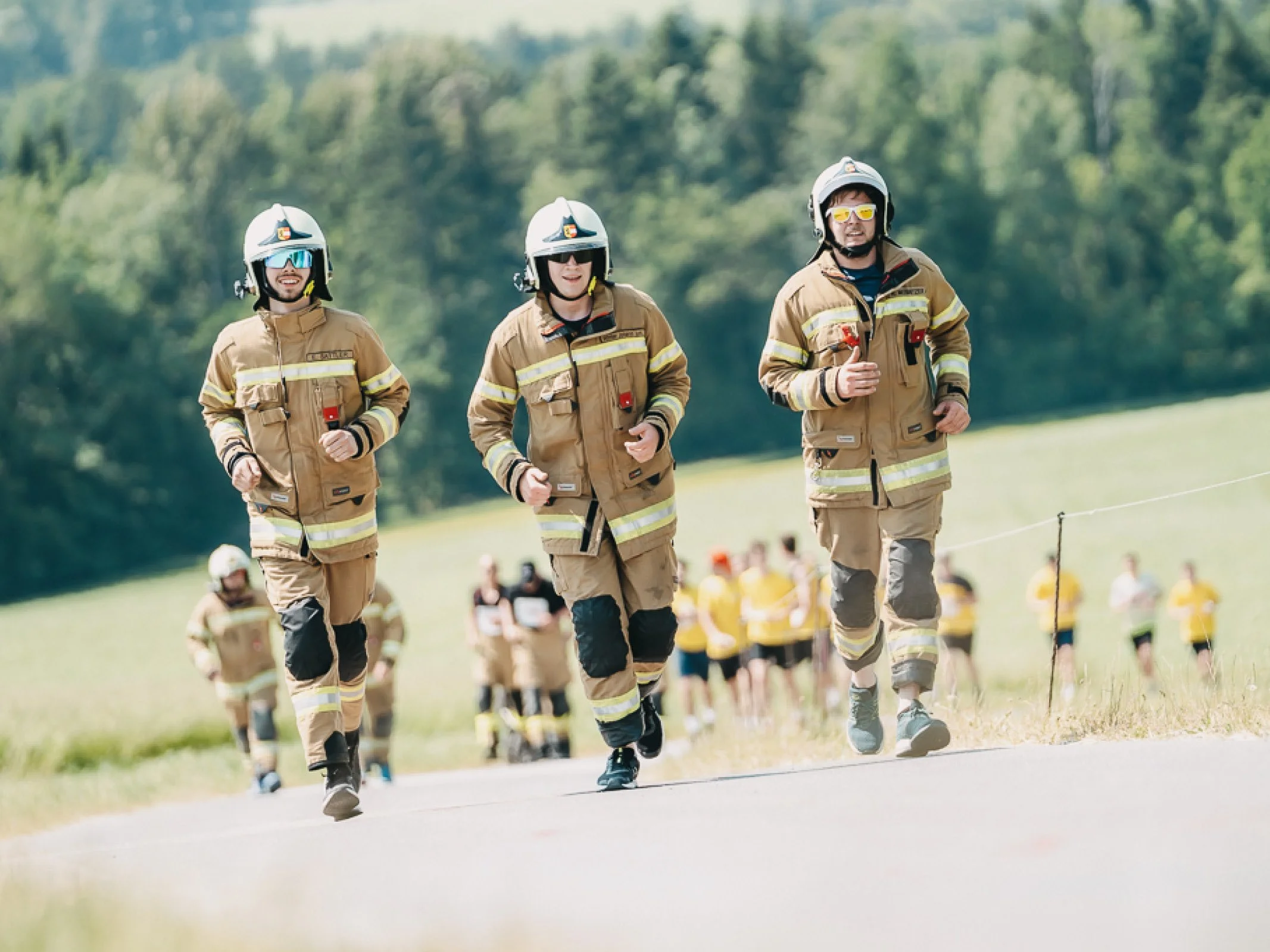 Drei Feuerwehrmänner der Freiwilligen Feuerwehr Radstadt in Uniform auf der Strecke beim Charitylauf lauf:feuer 2023 in Elixhausen