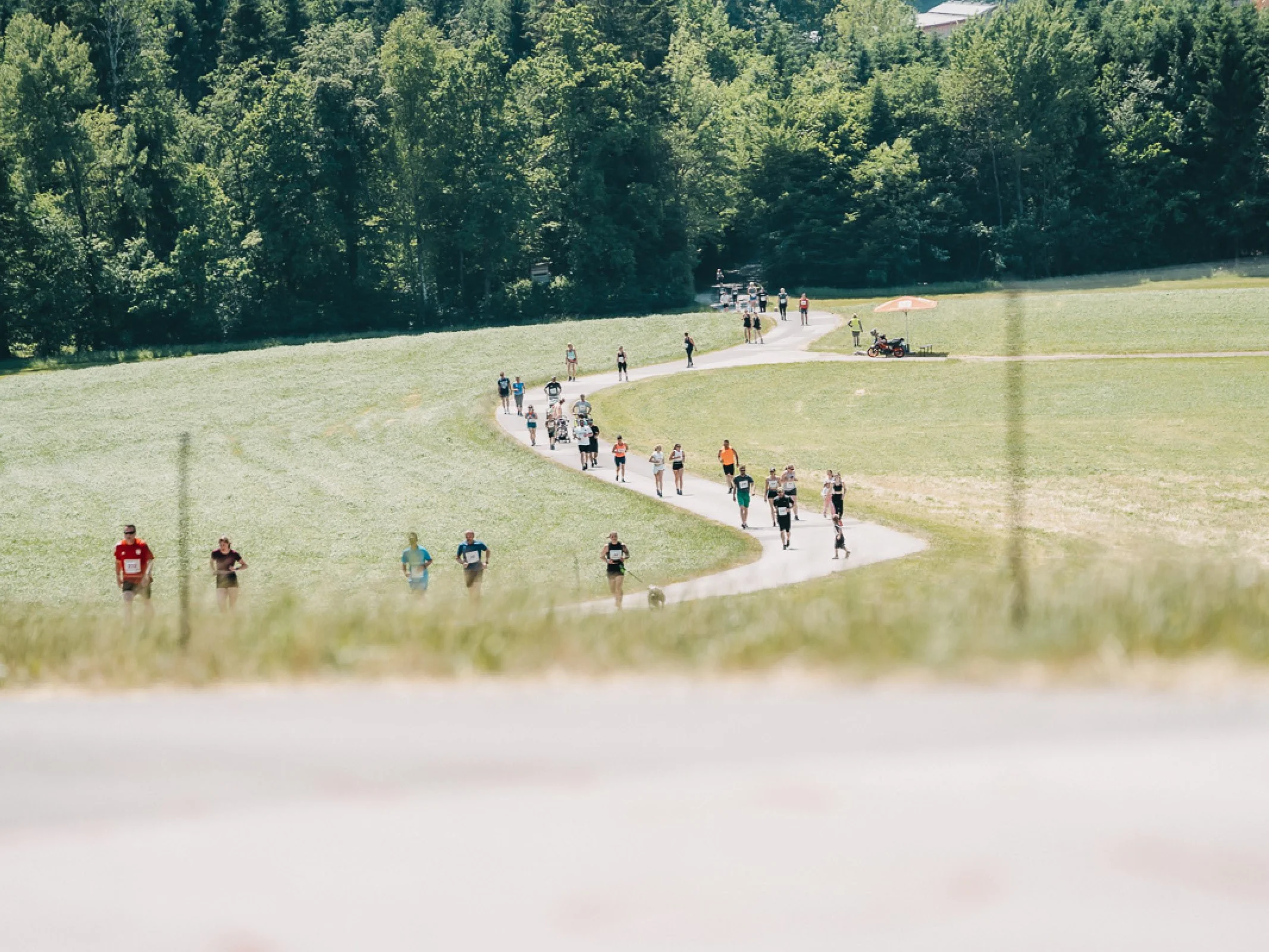 Laufstrecke mit Teilnehmerinnen und Teilnehmern beim Charitylauf lauf:feuer 2023 in Elixhausen