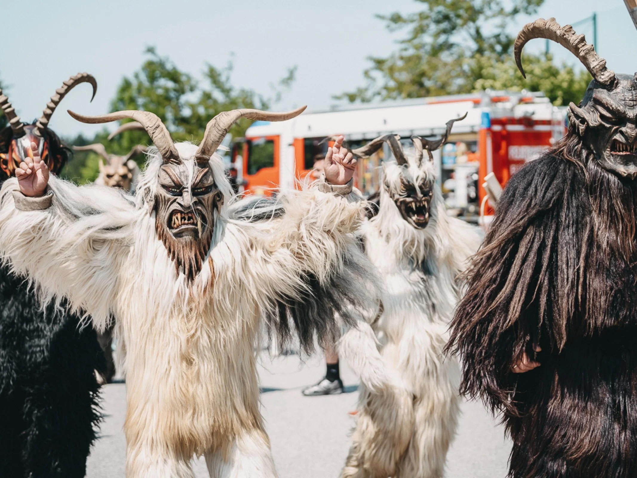 Vier Krampusse mit Maske laufen auf der Strecke beim Charitylauf lauf:feuer 2023 in Elixhausen