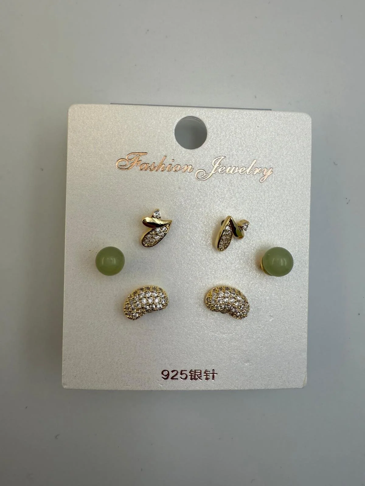 Set of four gold and silver earrings with rhinestones on a white jewelry card labeled "Fashion Jewelry" and "925".