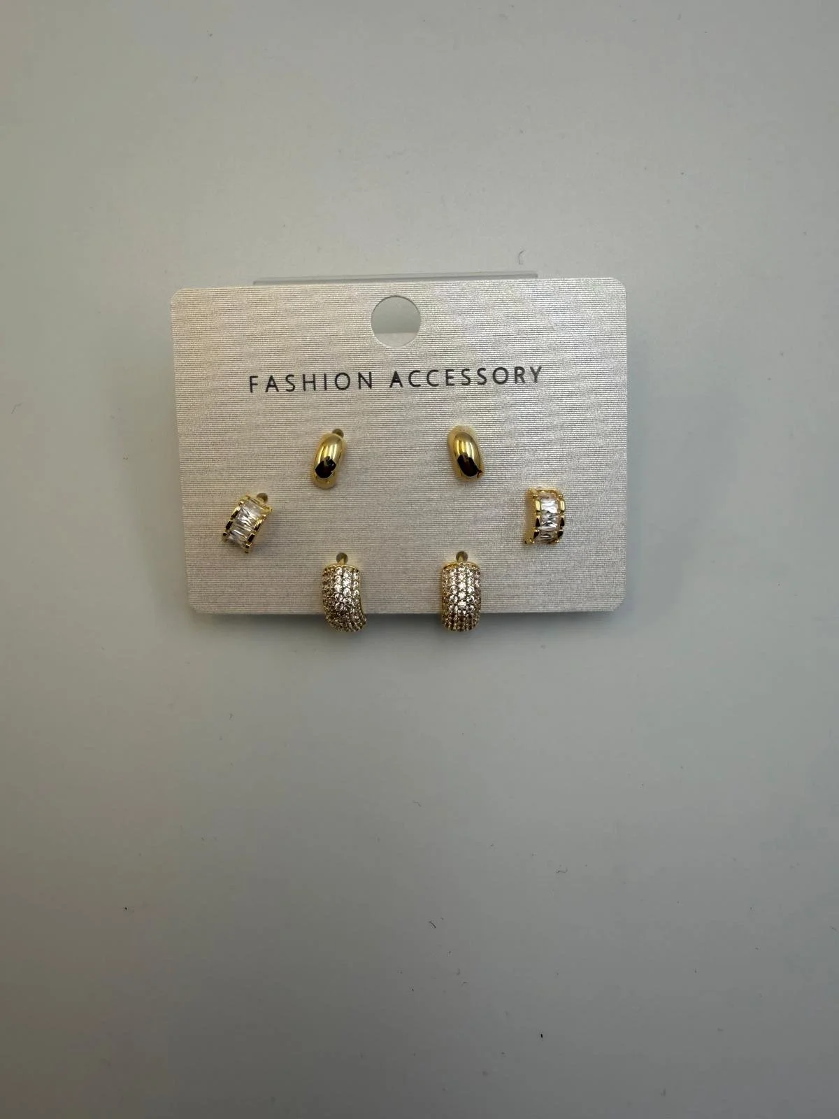 Set of four pairs of gold and silver earrings on a white card labeled 'Fashion Accessory'.
