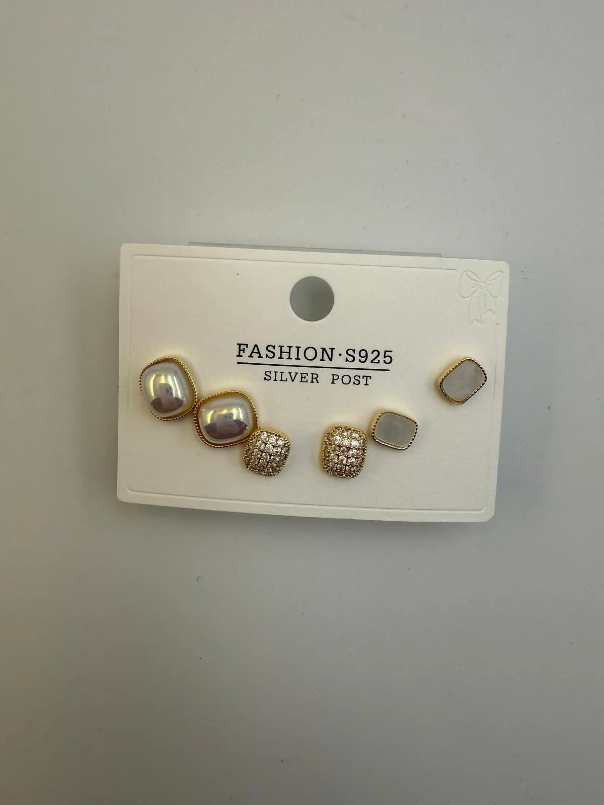 Set of six fashion earrings on a white card, labeled 'Fashion S925 Silver Post' with small decorative bow in the top right corner. The earrings include two large silver pearls, two square rhinestone-studded silver studs, and two plain square gray studs.