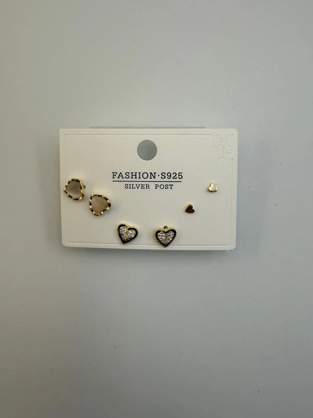 Four pairs of small earrings displayed on a white card labeled 'FASHION S925 SILVER POST' on a light gray background.
