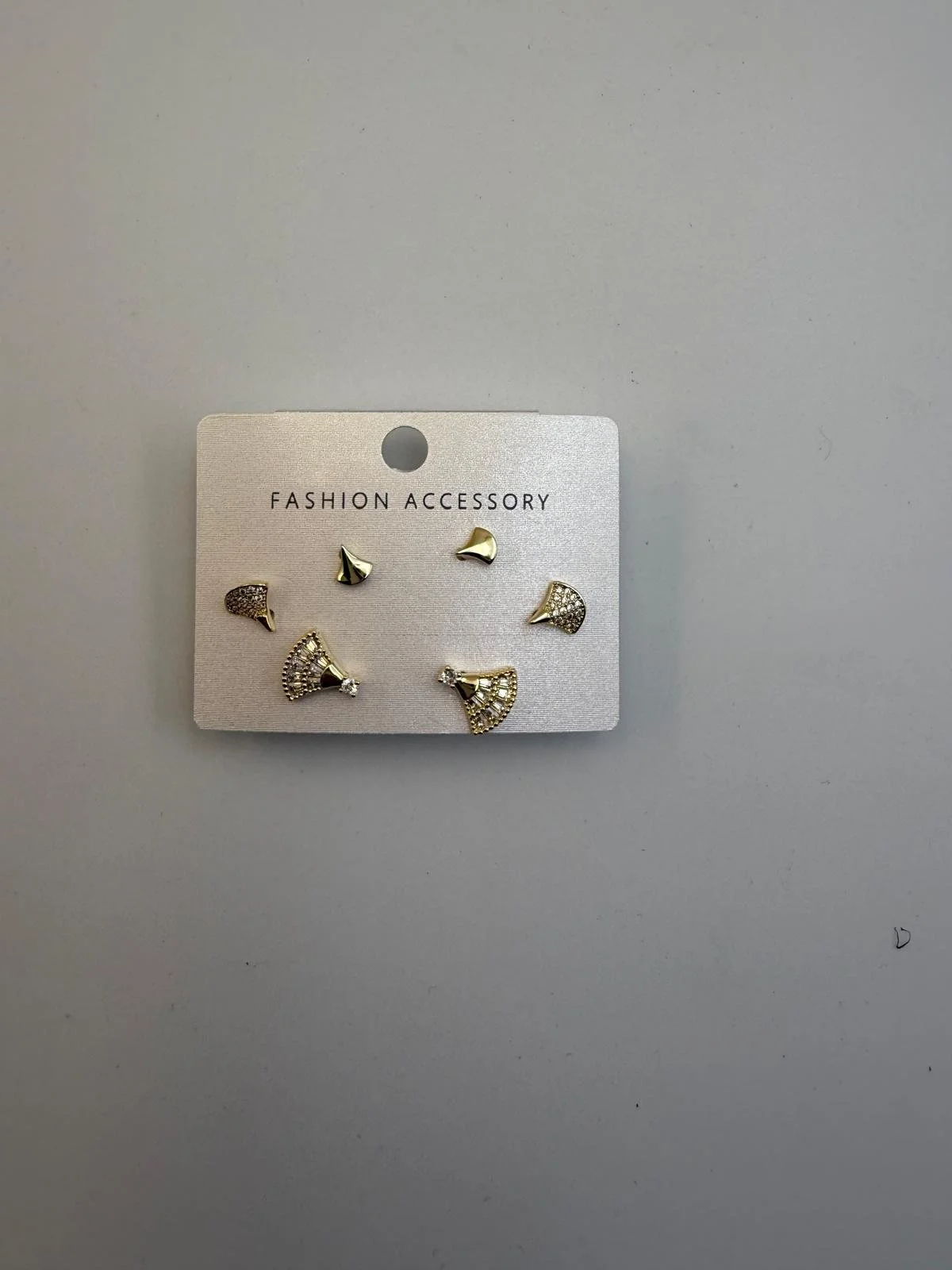 Set of six gold and silver fashion earrings with decorative stones on a gray card labeled 'Fashion Accessory' against a gray background.