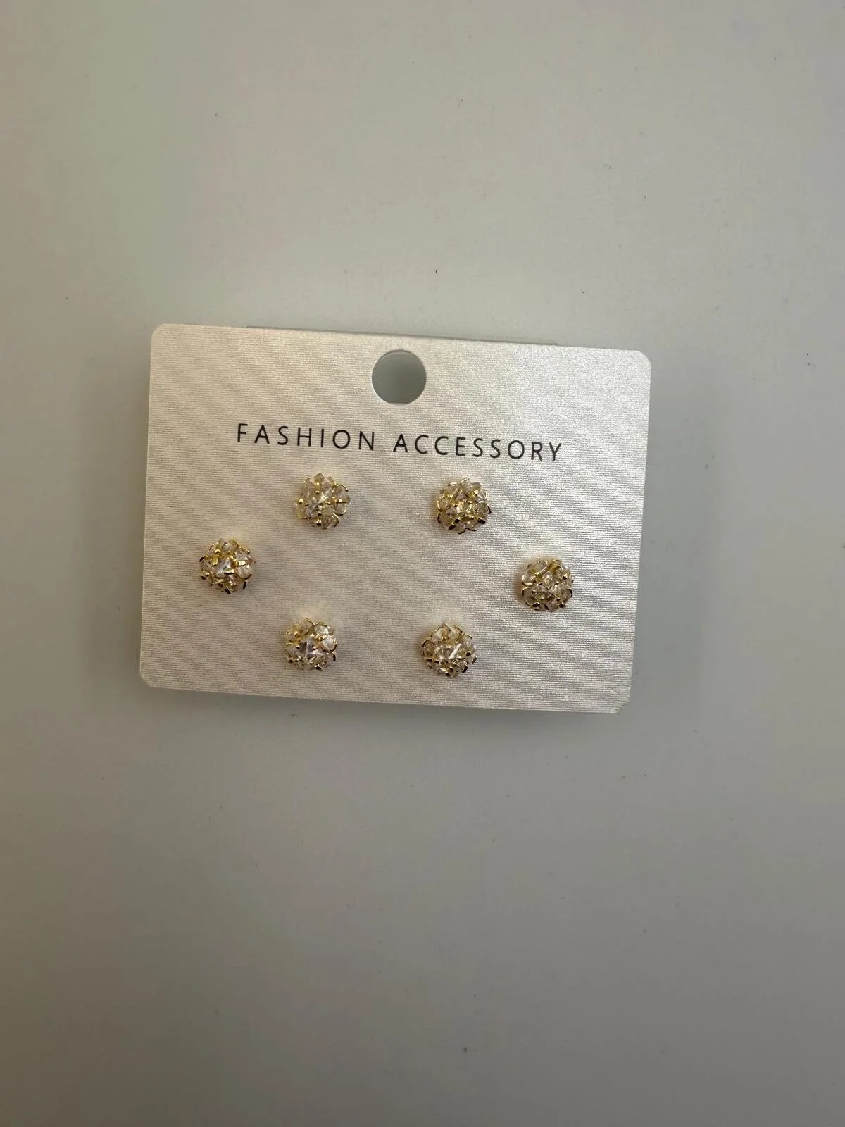 Set of six gold and crystal flower-shaped fashion accessories with the label 'FASHION ACCESSORY' on gray cardstock
