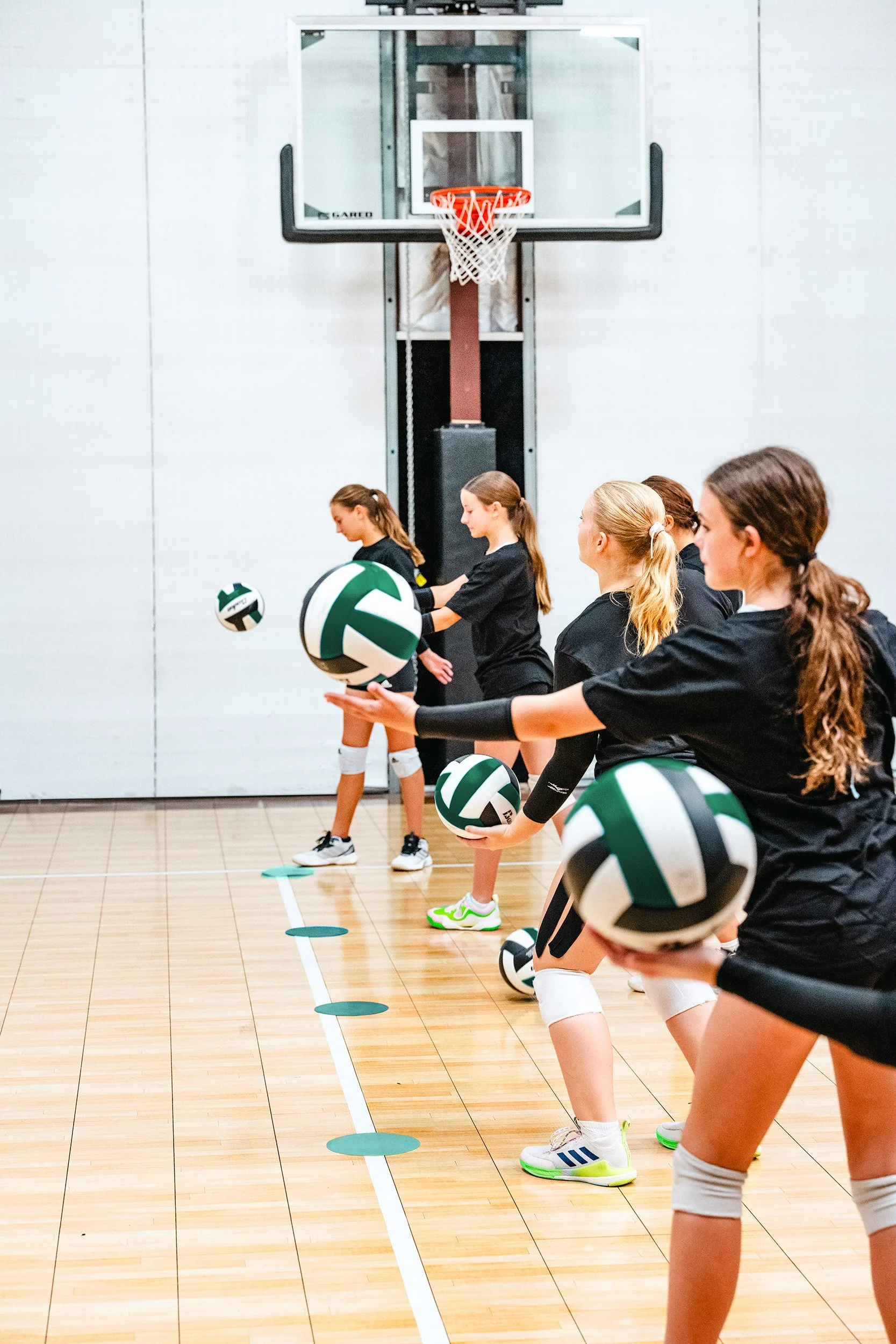 Competitive youth volleyball athletes training with controlled ball handling drills in Dripping Springs