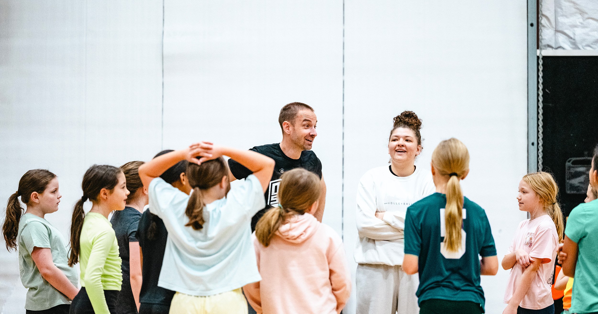 Summer camp group high-fiving coach during team activity in Dripping Springs