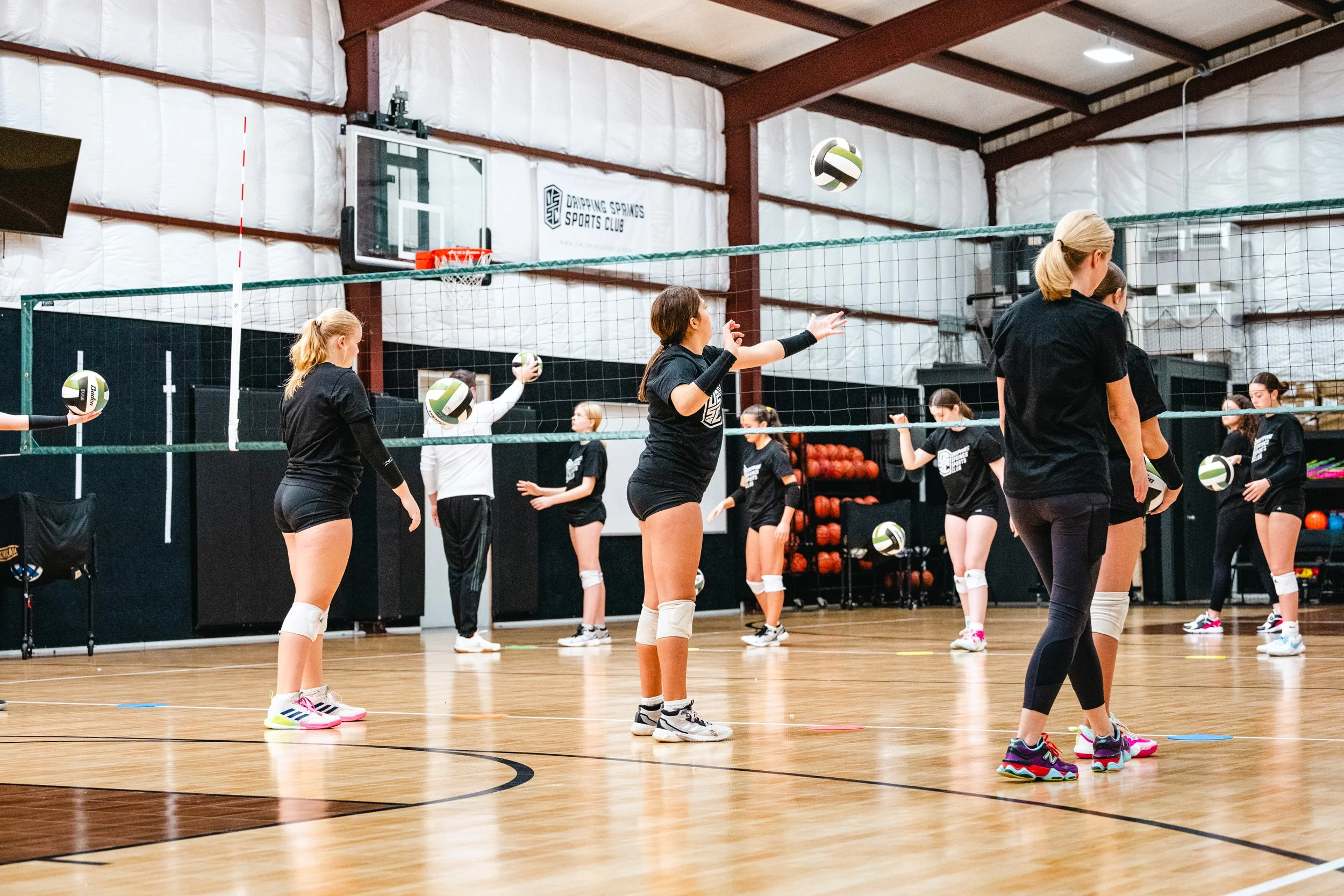 Youth volleyball team practicing serves and drills at Dripping Springs Sports Club