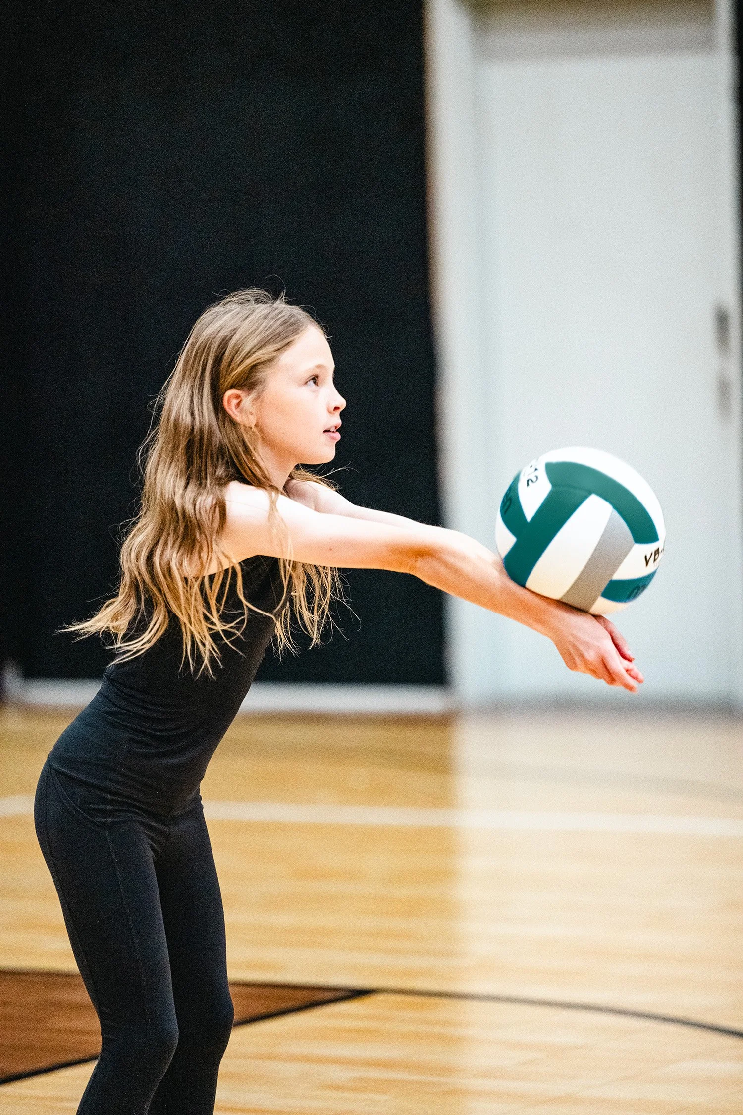 Young volleyball player practicing forearm pass during beginner clinic in Dripping Springs