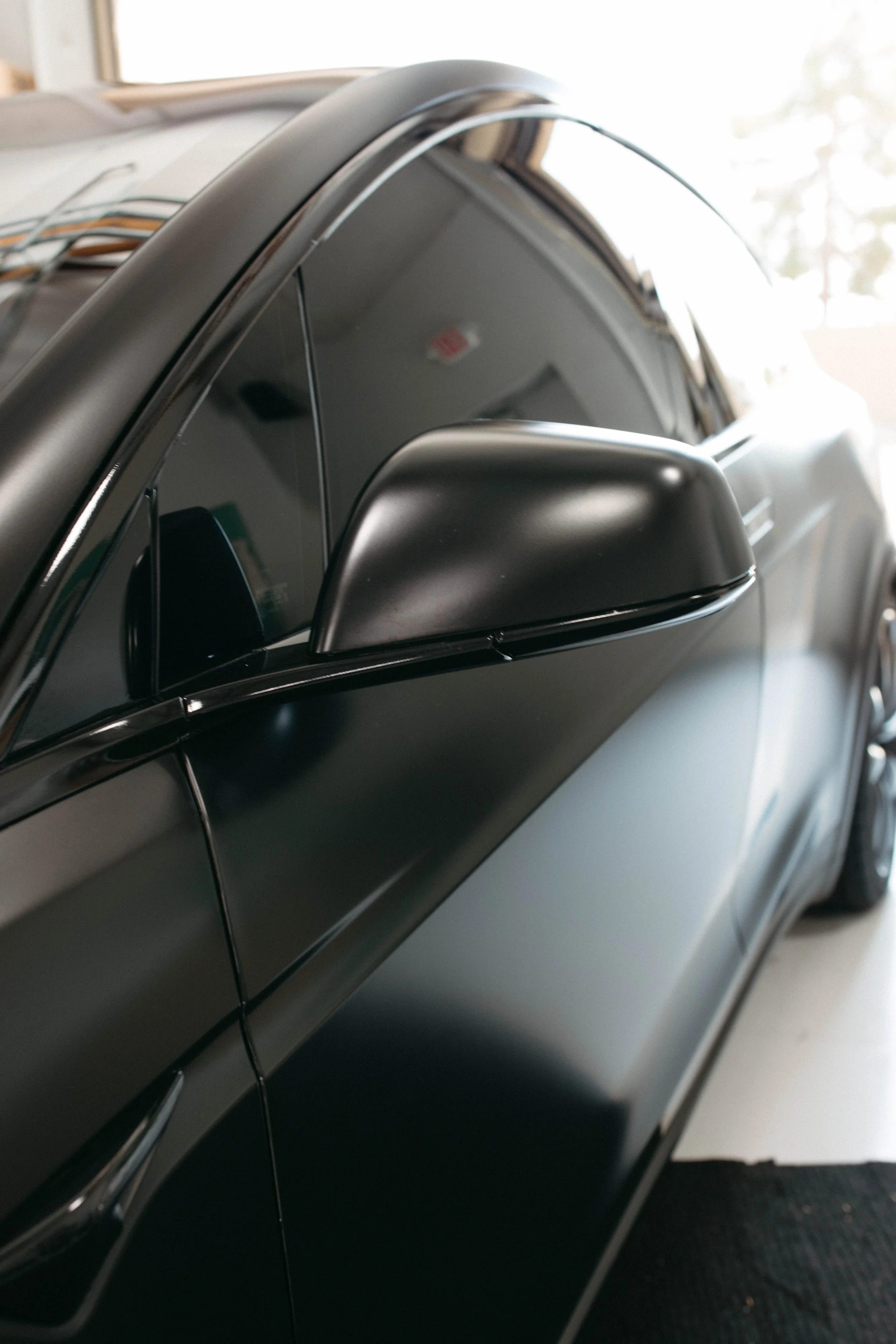 Close-up of a silver and black car door with a side mirror.