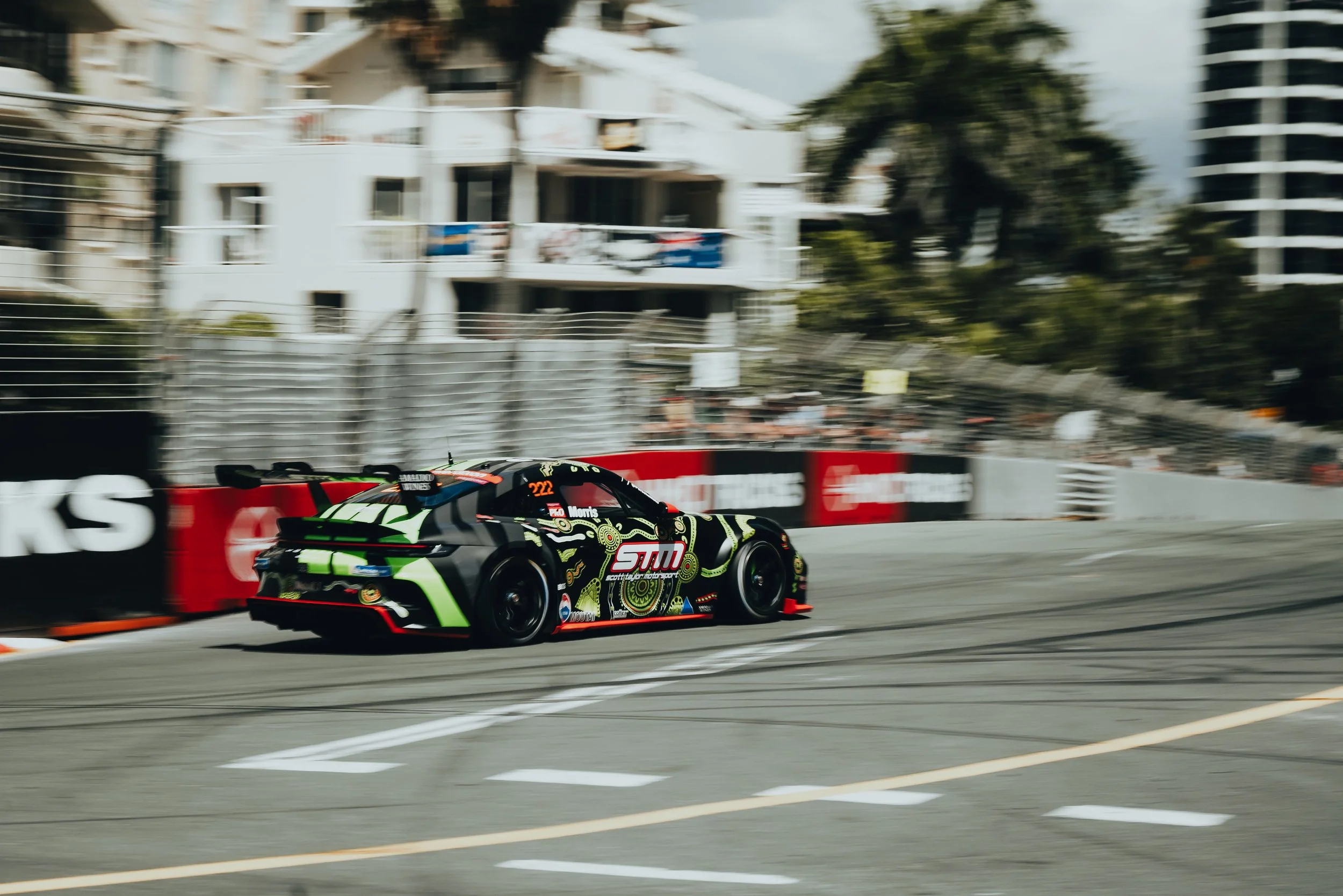 A race car speeding on a city street circuit during a motorsport event.