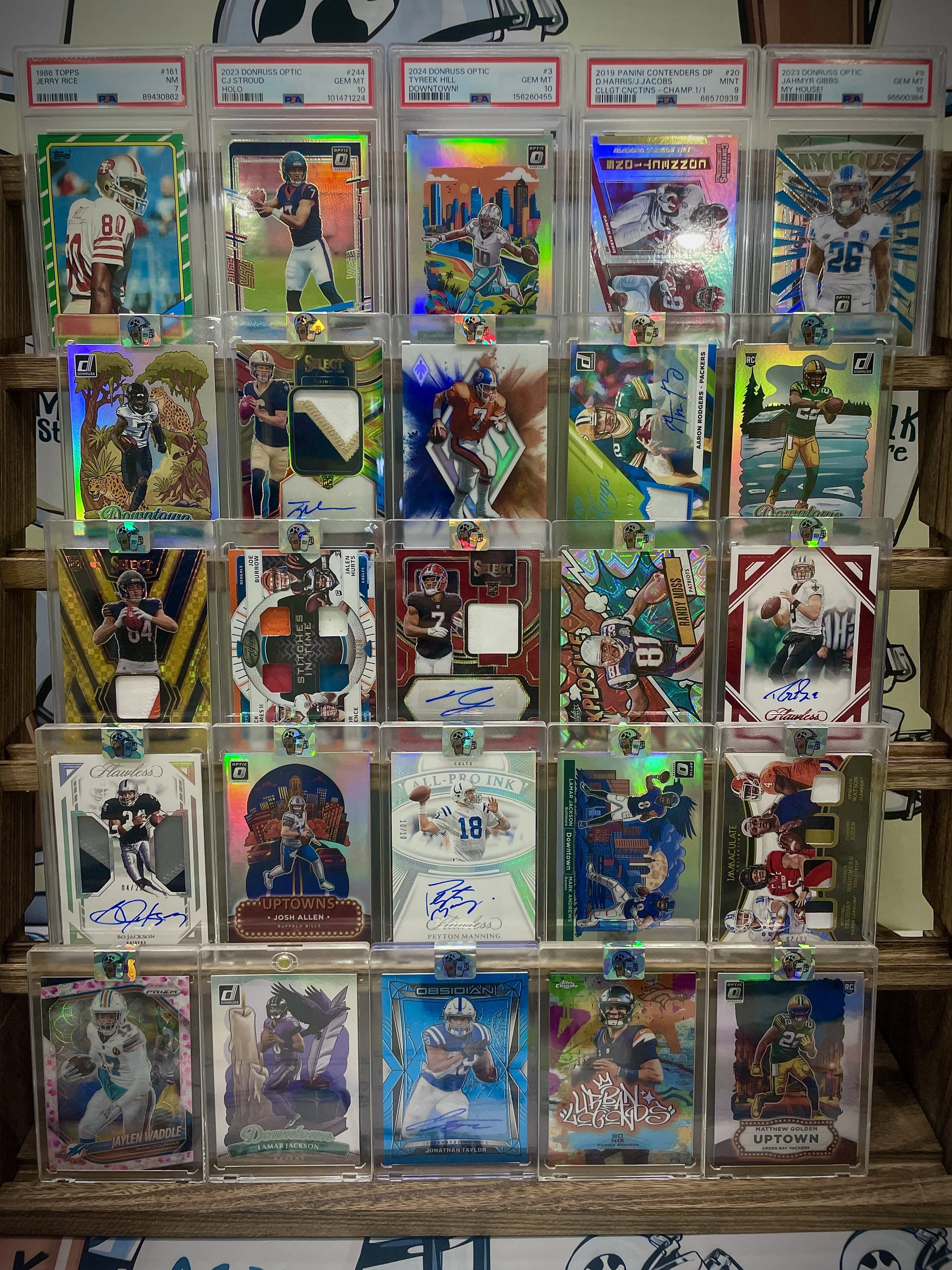 Collection of football trading cards in clear plastic holders displayed on a wooden surface.