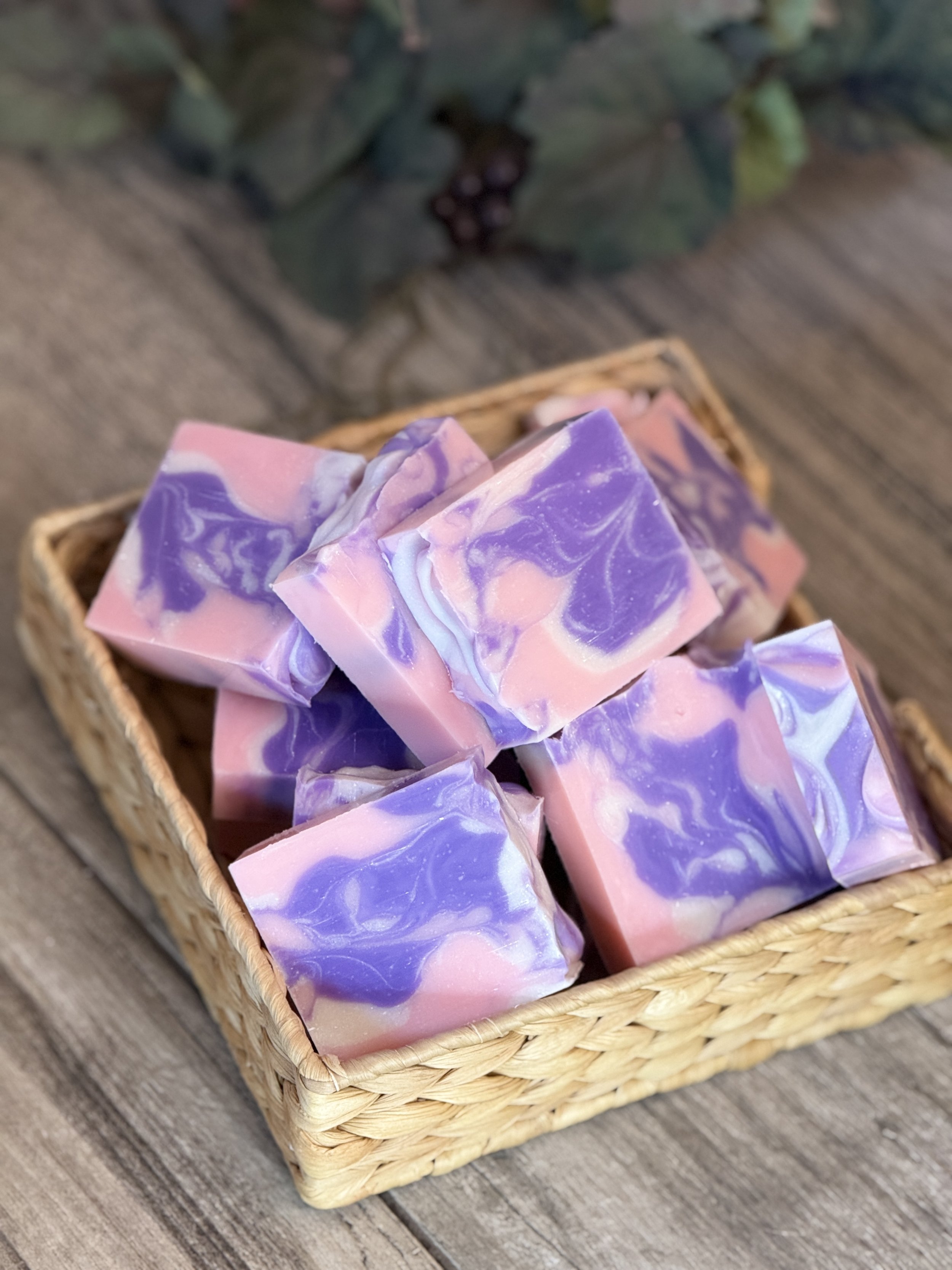 Purple and pink handmade soap in basket with floral scent