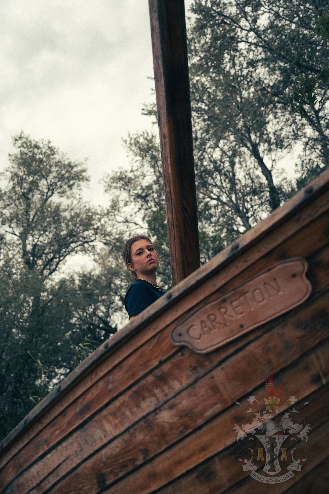Portrait of a female handler in a navy polo shirt overlooking the stream and surrounding nature.