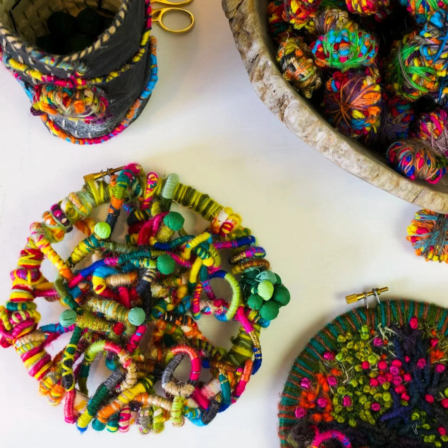 Colorful yarn and fabric crafts arranged in baskets and on a table.