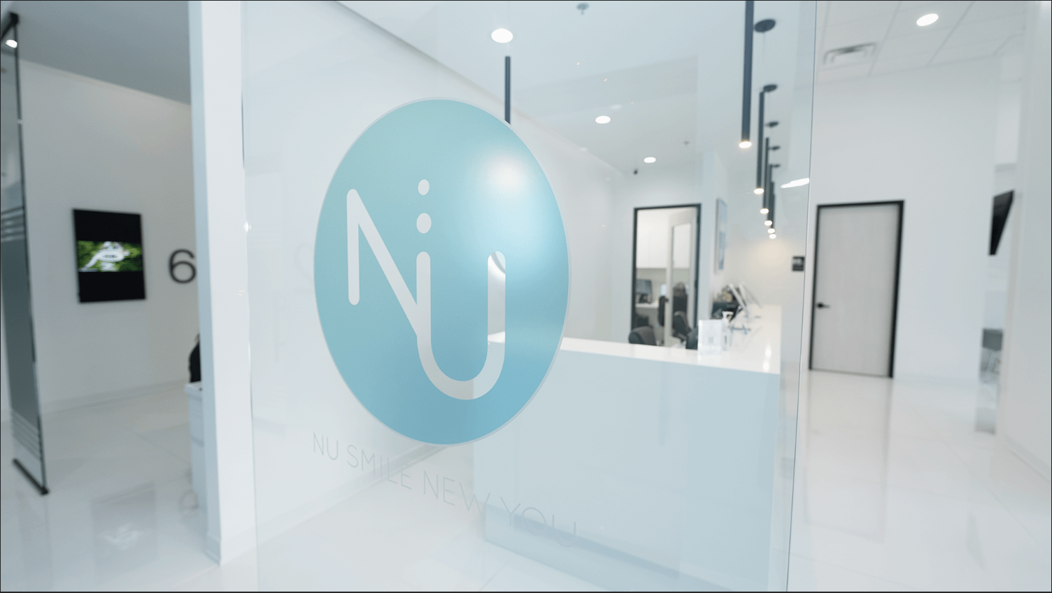 Looking up at two tall skyscrapers with reflective glass windows against a clear blue sky.