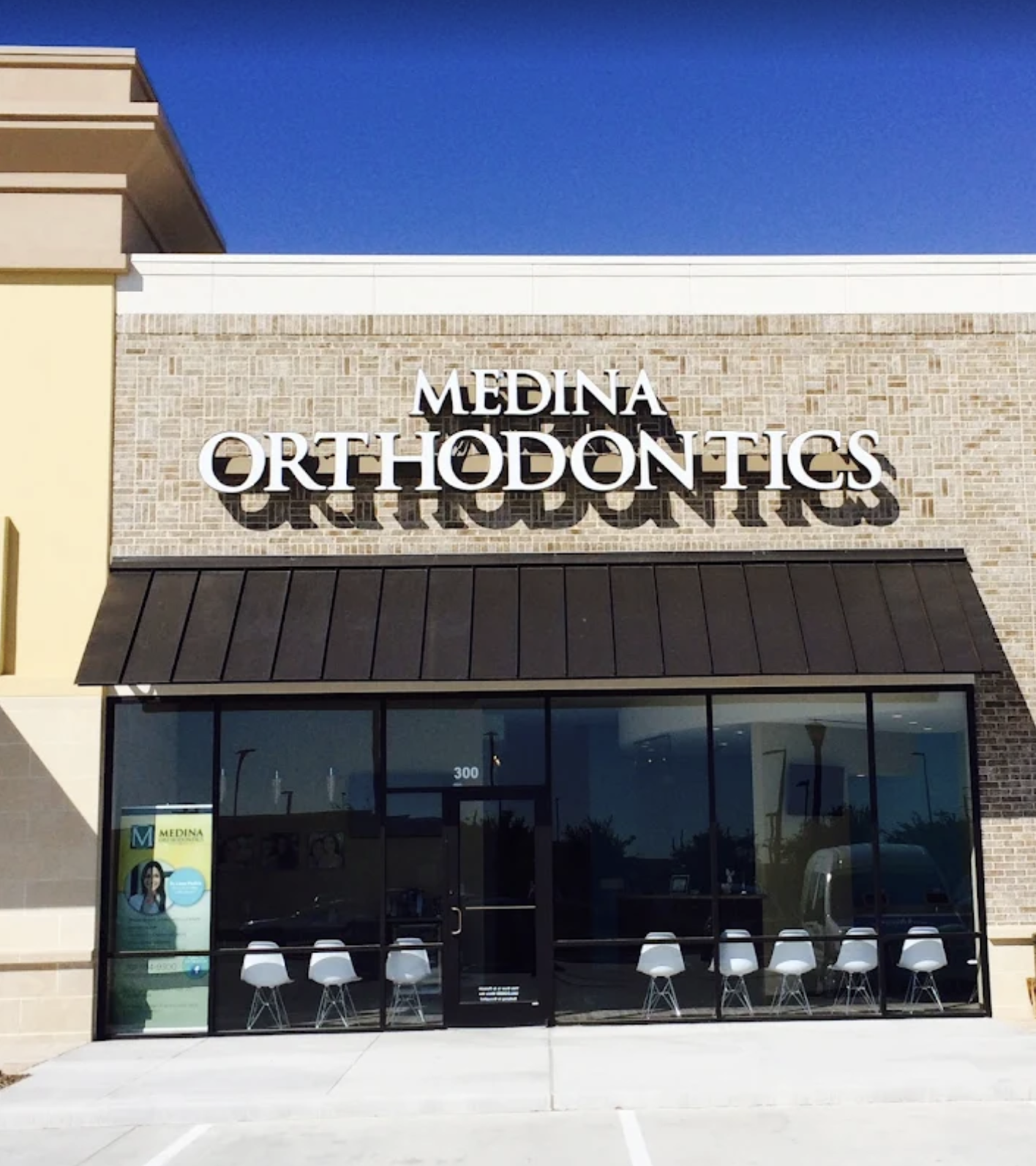 Front view of Medina Orthodontics office with large signage above the entrance, black awning, and glass doors and windows.