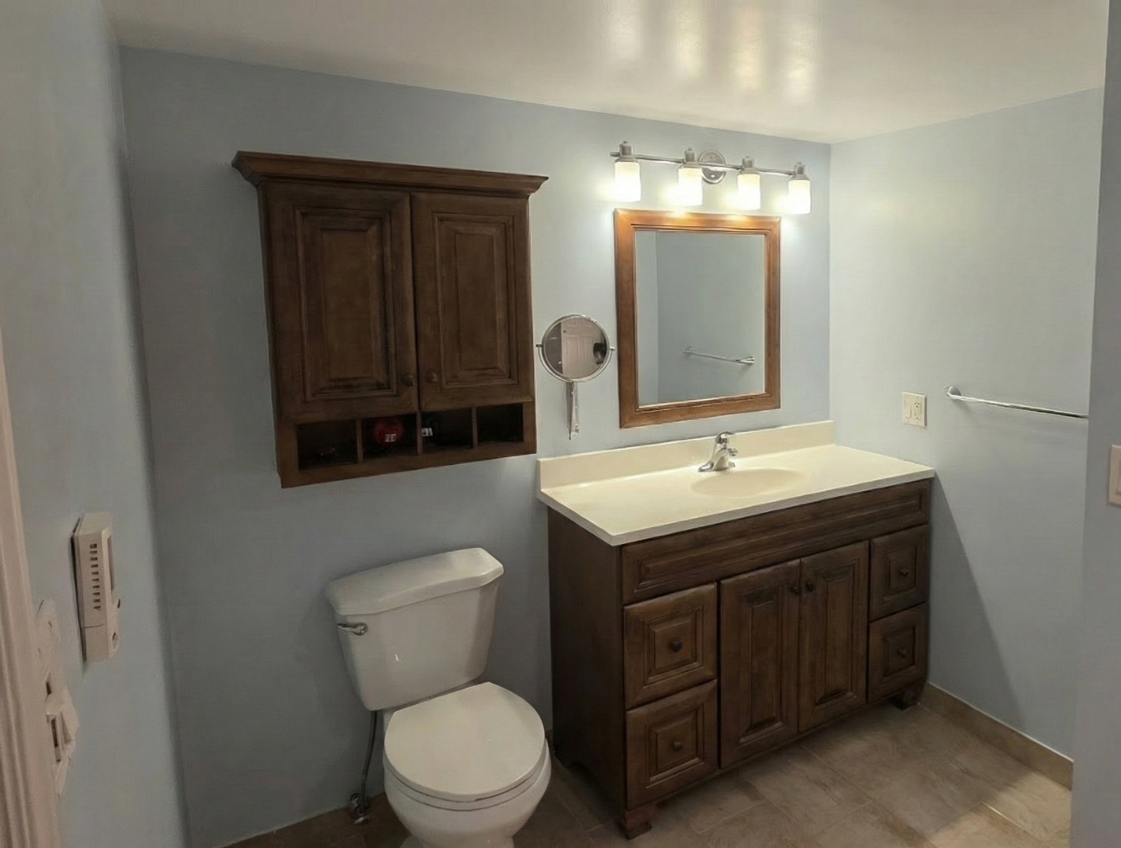 Interior painting in Cambridge — bathroom with dark wood vanity and light grey walls painted by Major Painting