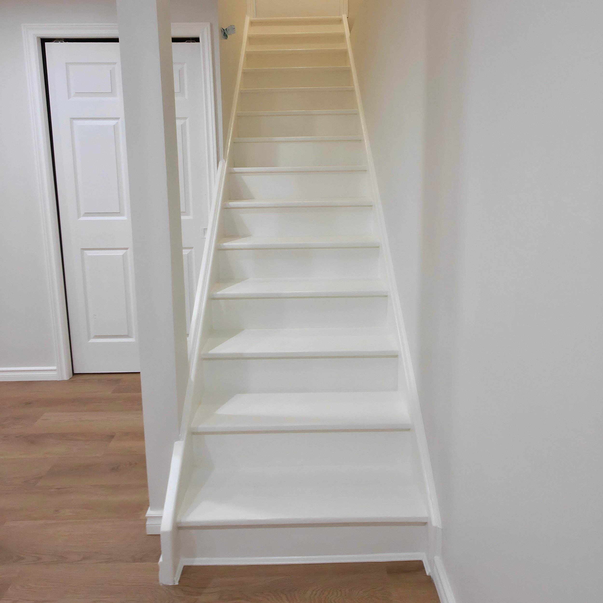 Staircase painting and refinishing with white painted risers and railings in Kitchener and Waterloo for clean modern interior finish