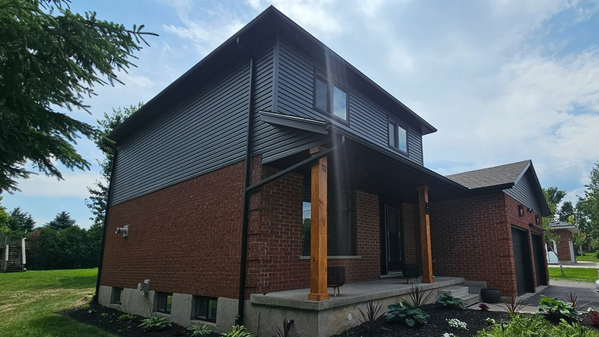 Exterior painting and refinishing project in Kitchener Waterloo showing multi-level home with brown composite siding and trim work