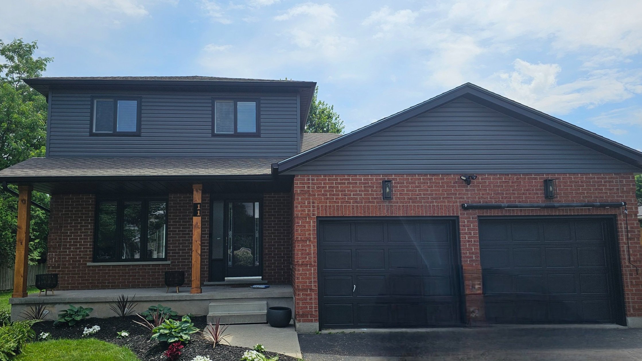Completed exterior painting project in Waterloo Region showing modern two-storey home with brick facade and grey vinyl siding by Major Painting