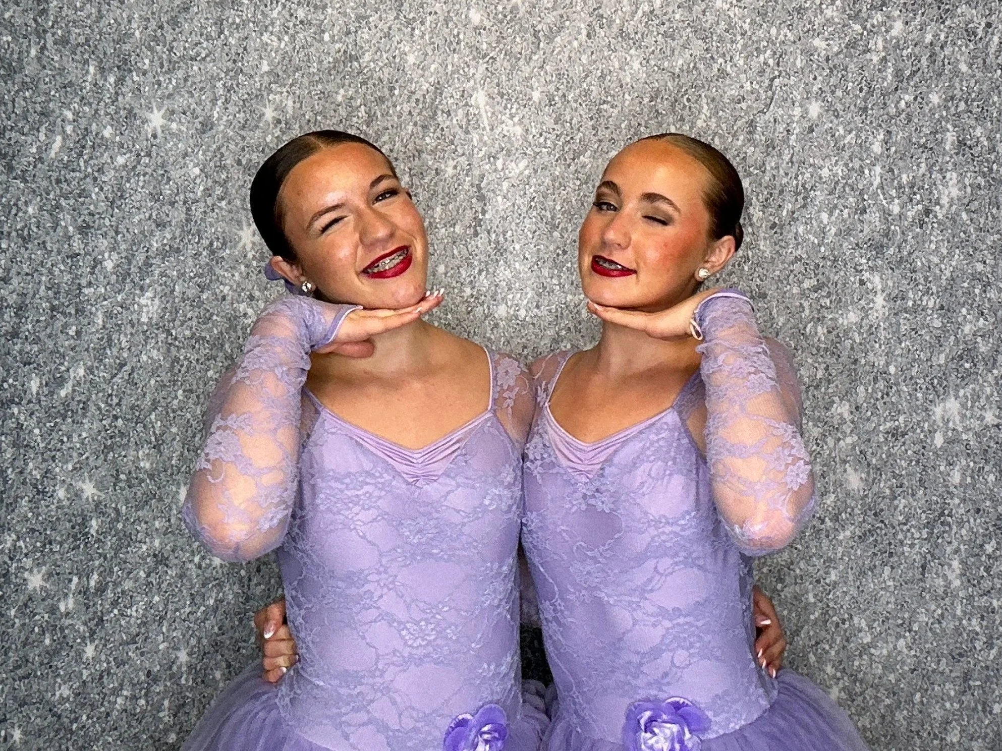 Dance studio students celebrating at a recital with a Pop & Pose Photo Booth and silver shimmer backdrop. We provide Photo Booth rentals for dance recitals, school events, competitions, and performances across Central Florida.