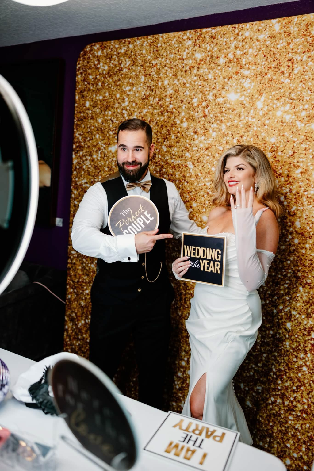 Bride and groom using a Pop & Pose Events Photo Booth with a gold sparkle backdrop at an Orlando wedding.