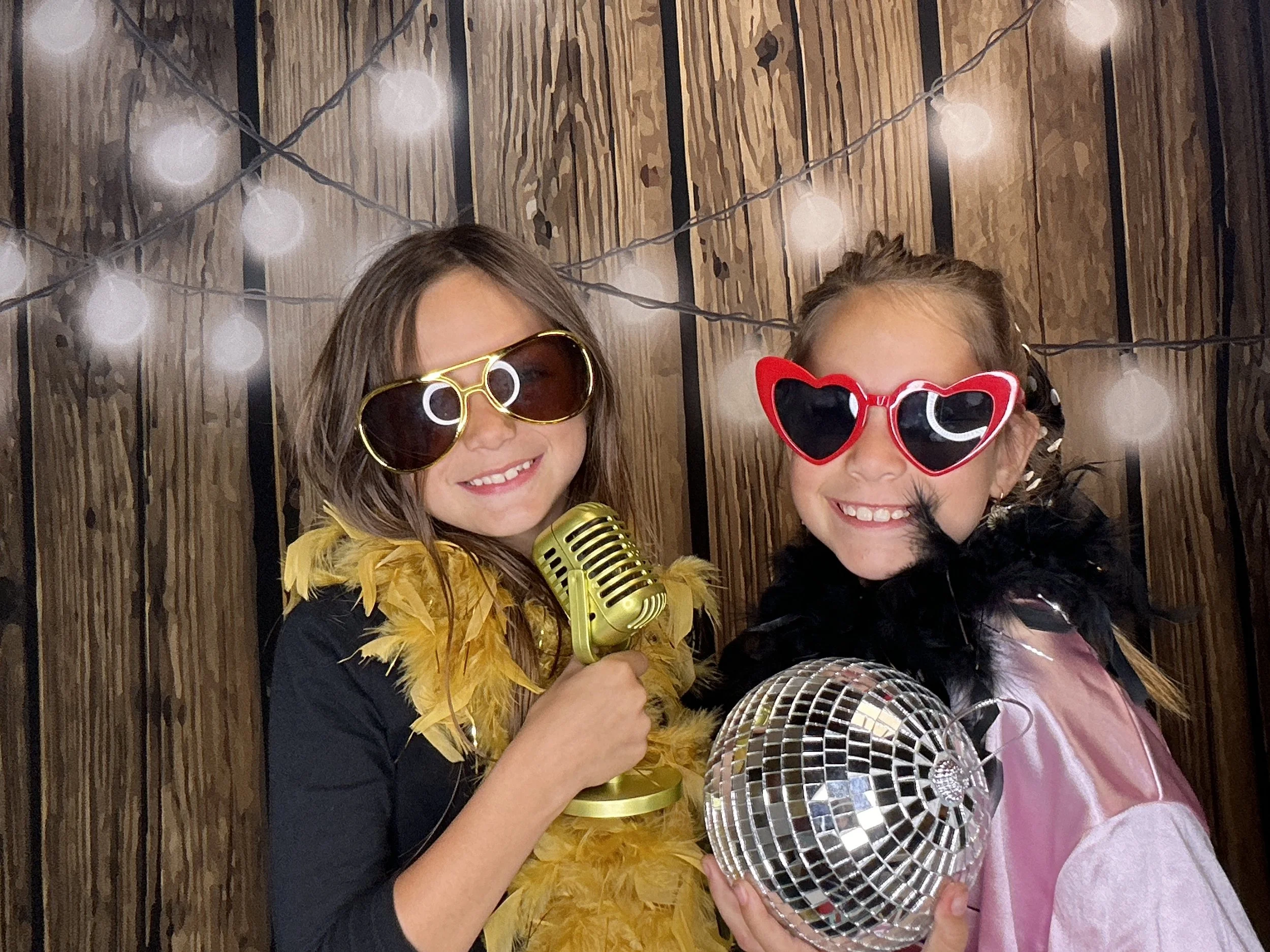Guests posing with fun Photo Booth props at a birthday party featuring Pop & Pose Events Photo Booth experience.