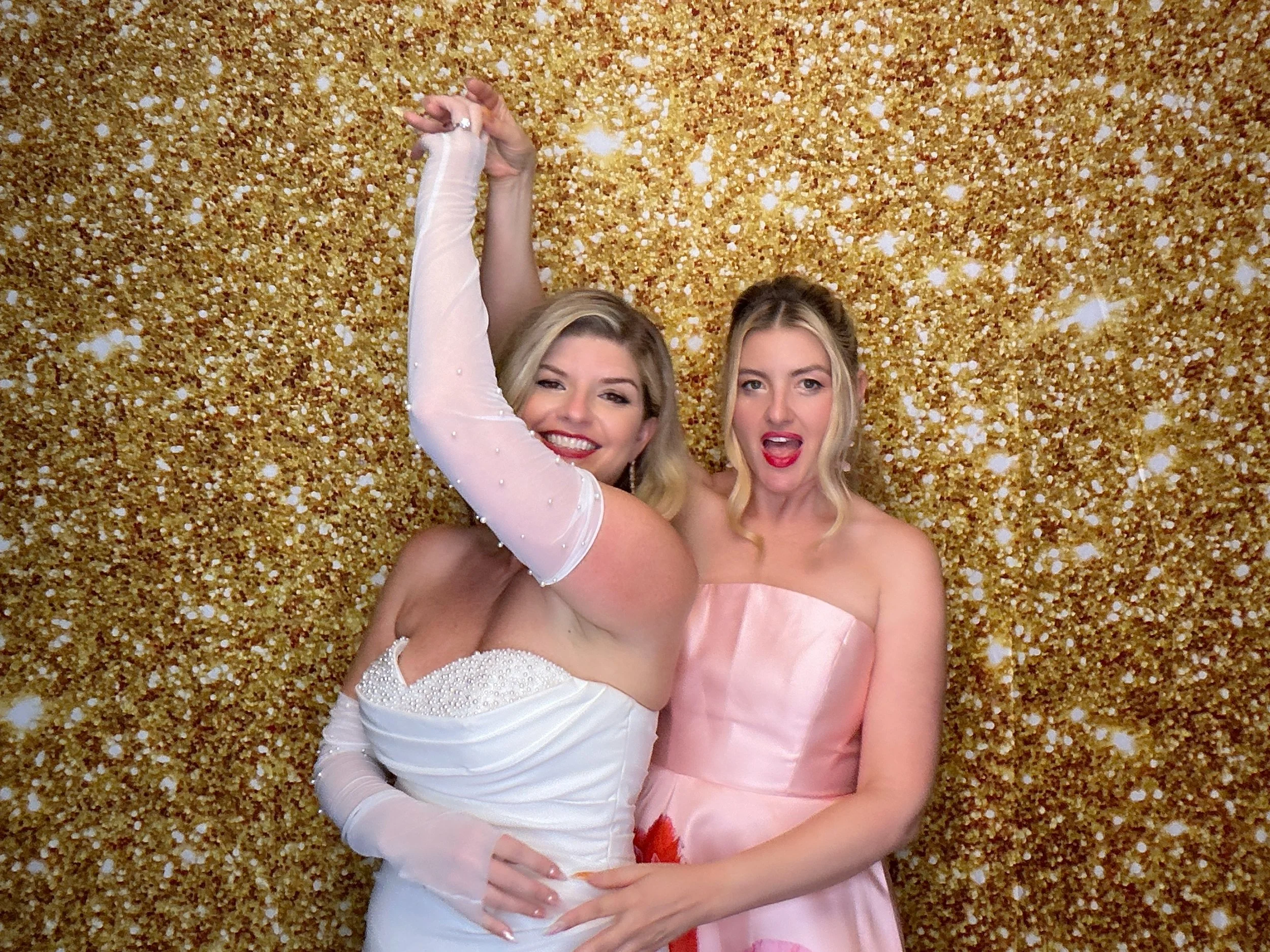 Friends posing at a wedding reception Photo Booth with gold glitter backdrop by Pop & Pose Events in Central Florida.