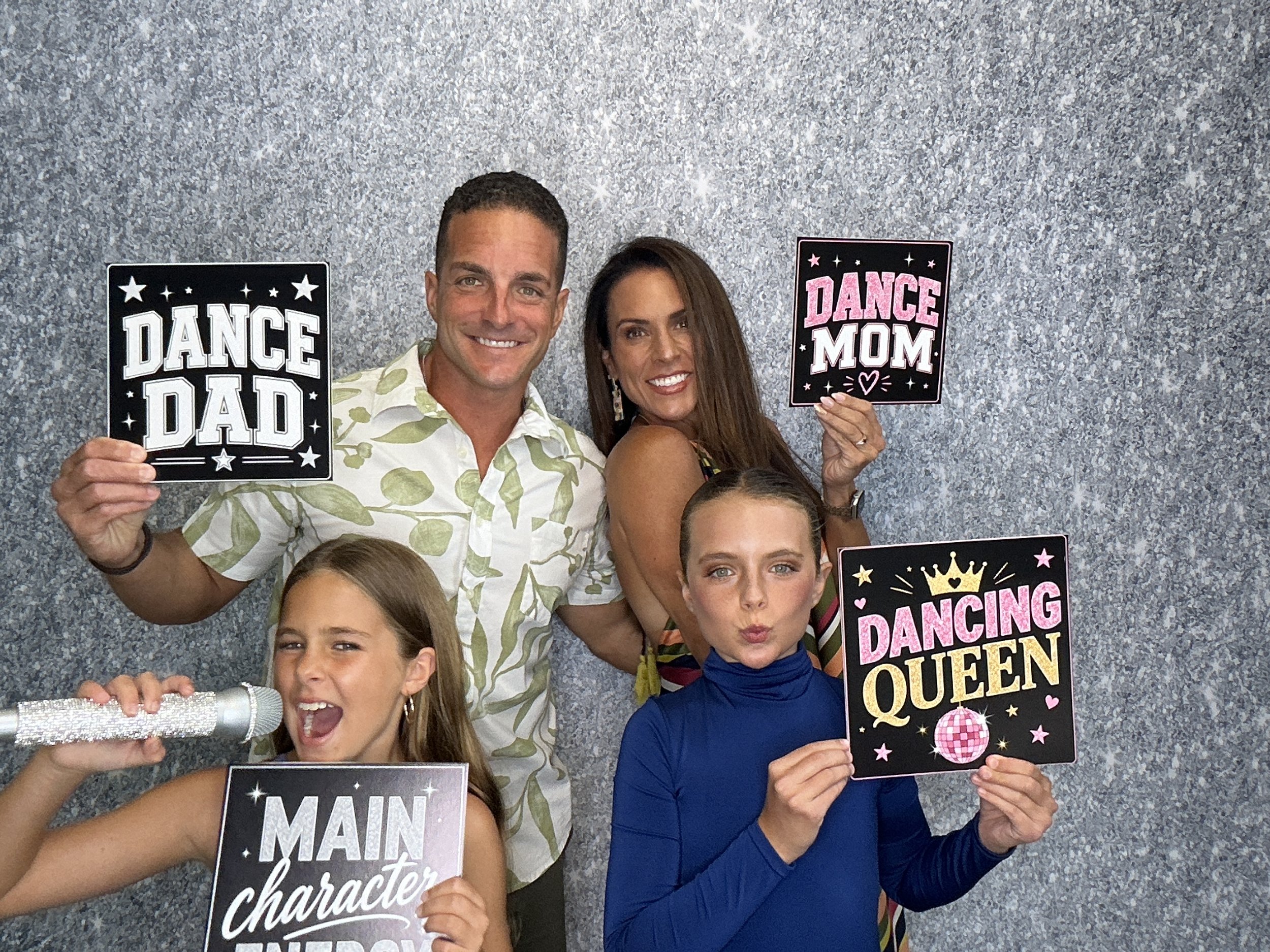 Family posing at a dance recital Photo Booth experience in Lake Mary, Florida with custom signs and keepsake prints,