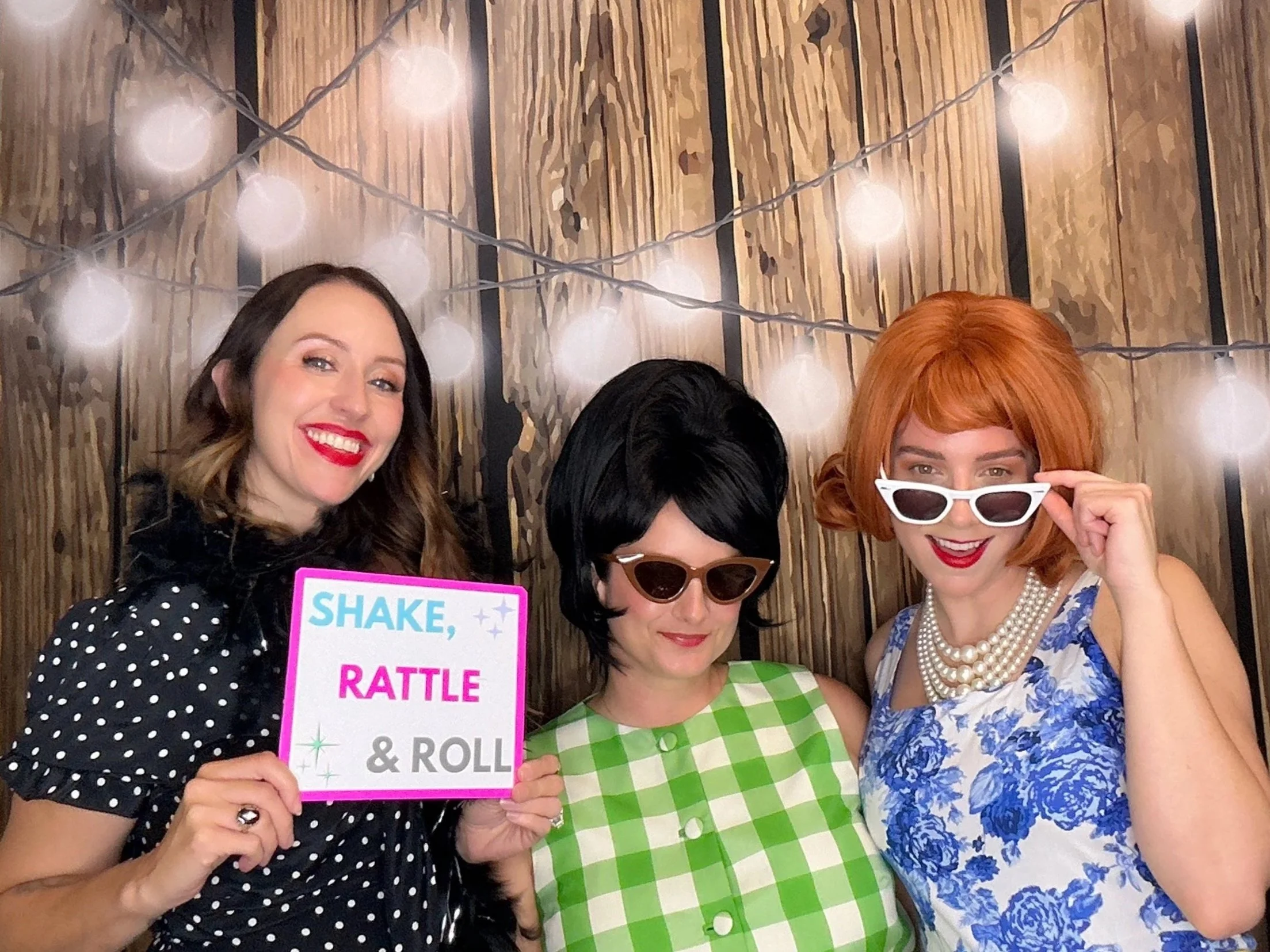 Guests enjoying a vintage-themed Photo Booth experience with a rustic wood backdrop and fun props. Pop & Pose Events provides themed Photo Booth rentals for birthday parties, corporate events, and celebrations throughout Sanford, Oviedo, and Orlando.