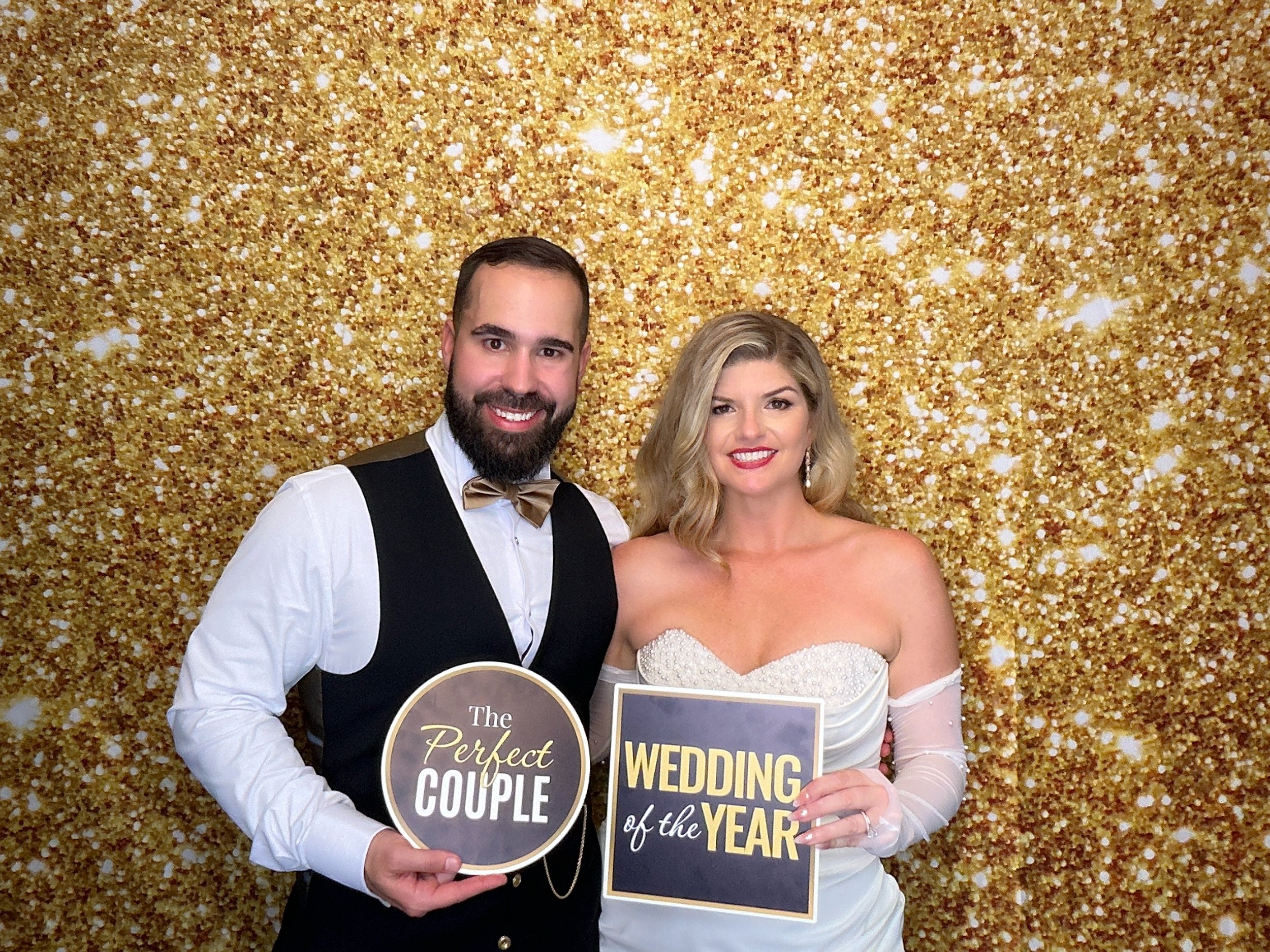 Bride and groom enjoying a wedding Photo Booth rental with gold glitter backdrop by Pop & Pose Events in Central Florida.