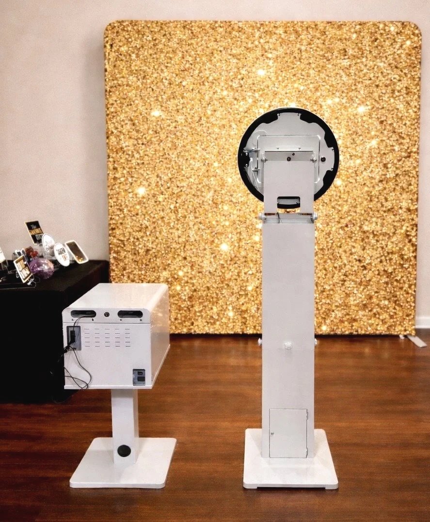 Modern photo booth setup with a gold glitter background at an event in the Orlando area, featuring an open- air Photo Booth with professional lighting.