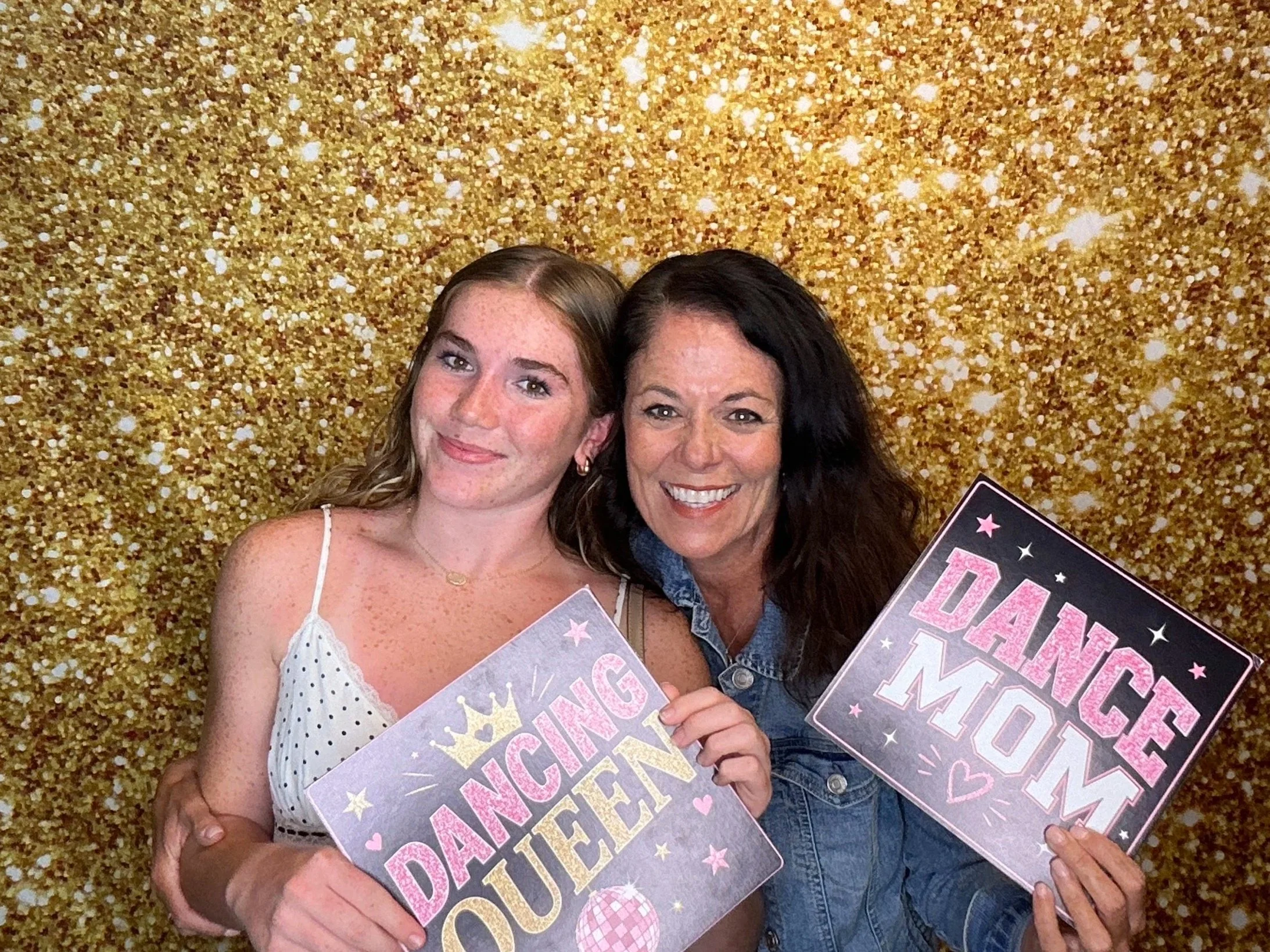 Guests posing with fun Photo Booth signs in front of a gold glitter backdrop during a celebration. Pop & Pose Events offers modern Photo Booth rentals for weddings, birthdays, graduation parties, and private events in Orlando and surrounding areas.