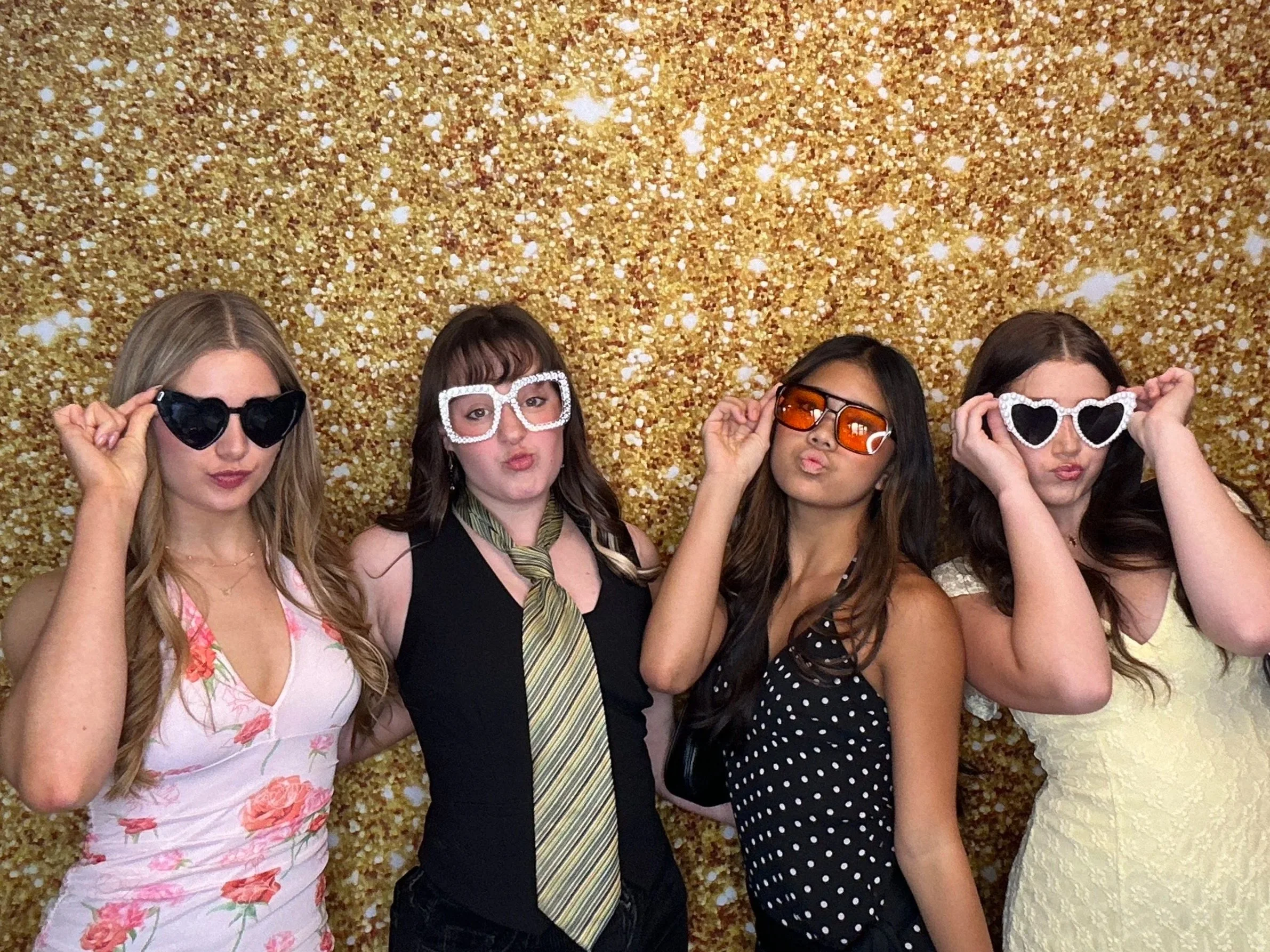 Guests posing together in front of a gold glitter backdrop at a celebration using a Pop & Pose Photo Booth in Lake Mary, Florida. Our Photo Booth rentals are perfect for weddings, birthday parties, corporate events, and school celebrations.