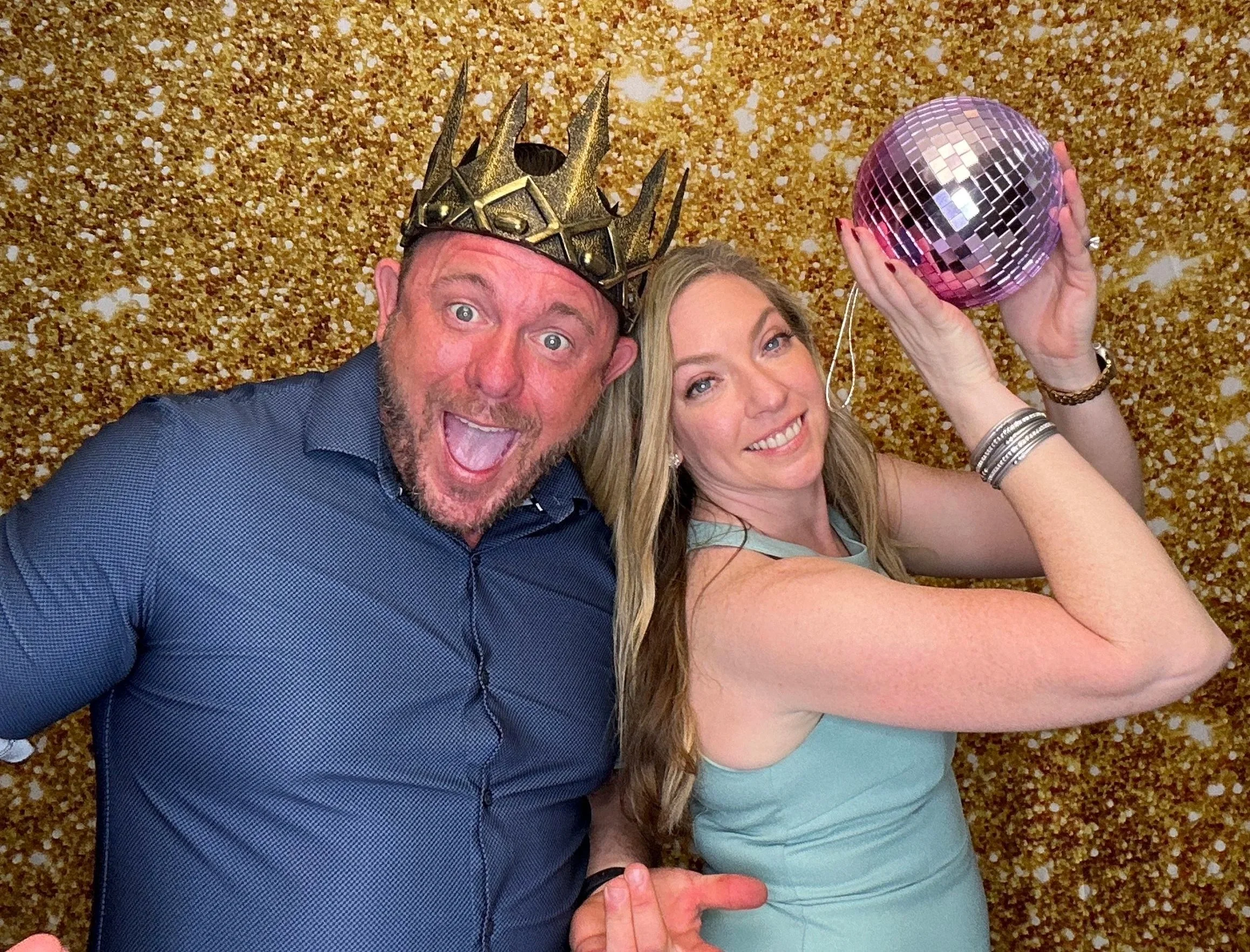 Photo Booth guests having fun with props and a disco ball at an event in the Orlando area, captured with a modern open-air Photo Booth setup